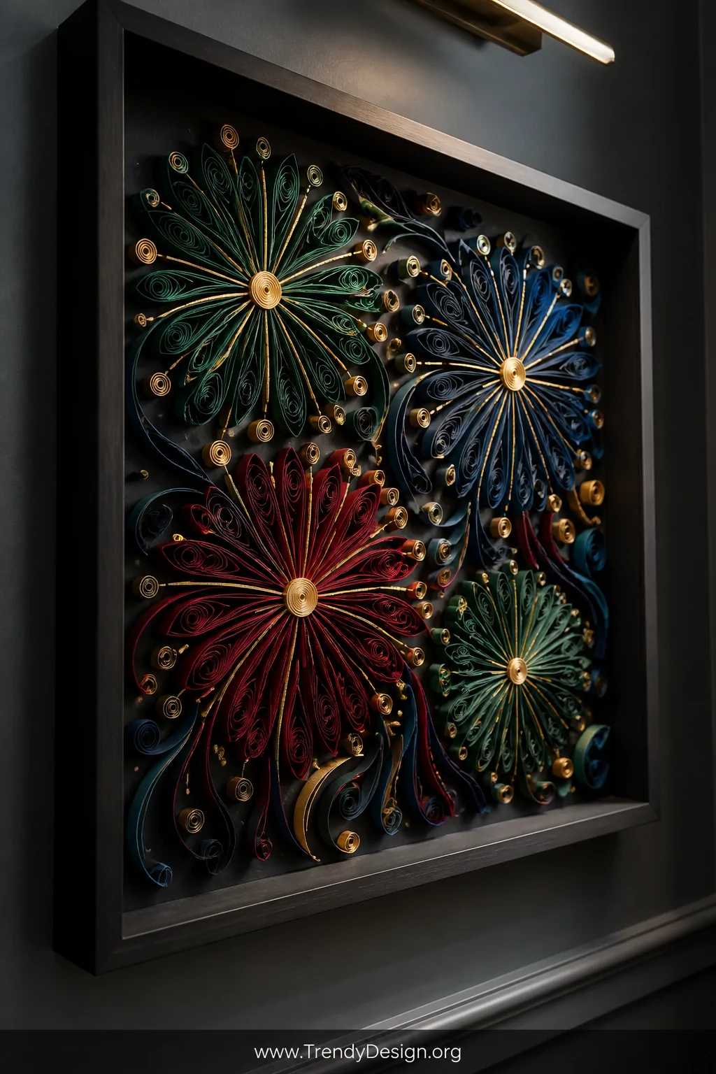 Close-up detail shot of a deep shadow box frame mounted on a charcoal gray wall, showcasing an intricate quilled paper firewo
