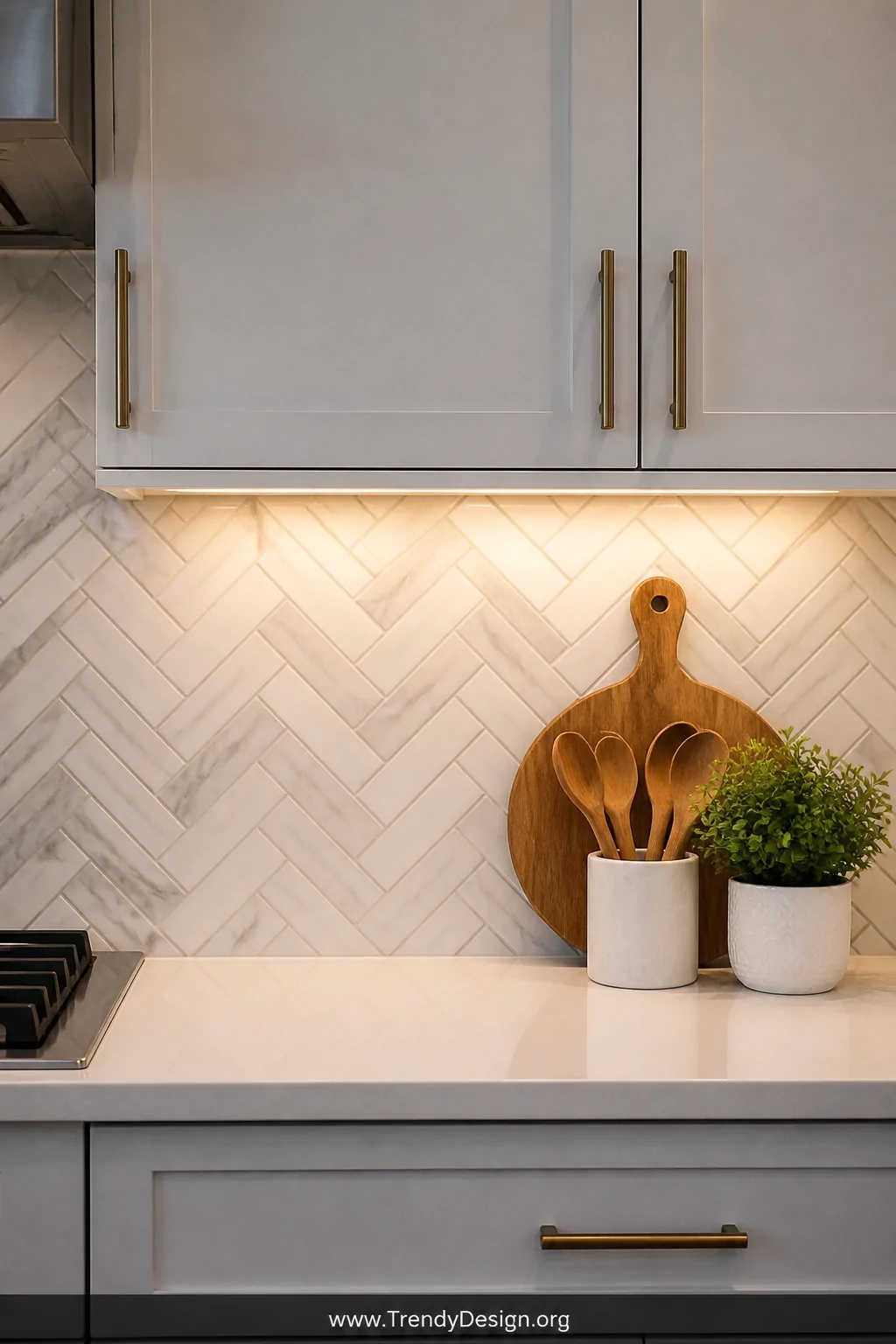 A medium shot of a kitchen countertop laid in a precise herringbone pattern using slim marble-look porcelain tiles with subtl