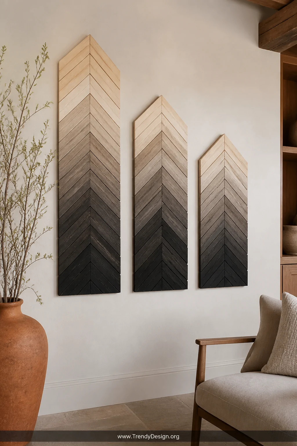 A medium shot of a gallery wall featuring three herringbone-arranged wood slat panels in varying sizes, displaying an ombre p