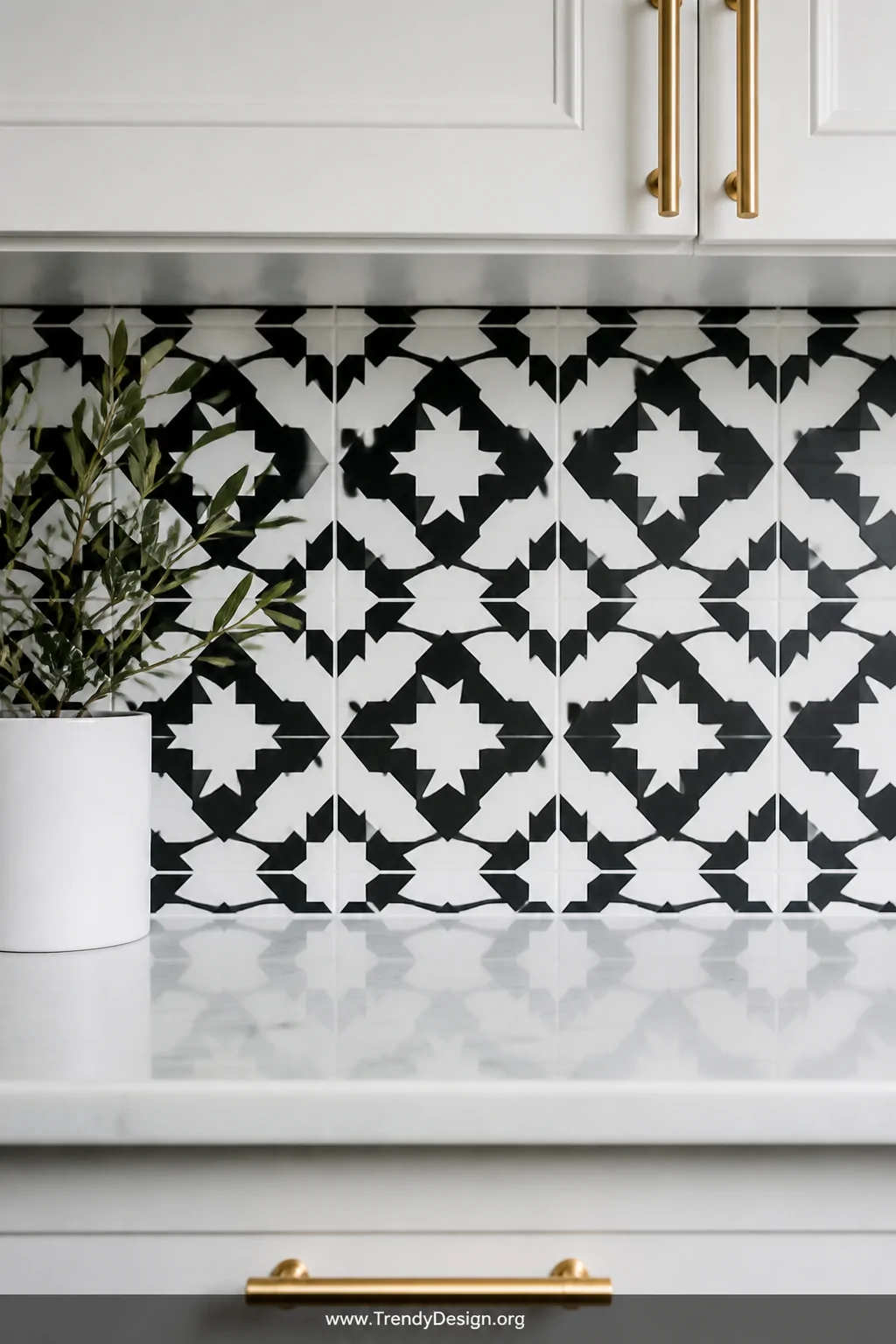 Close-up detail shot of a bold black and white geometric encaustic cement tile backsplash above a simple white marble counter