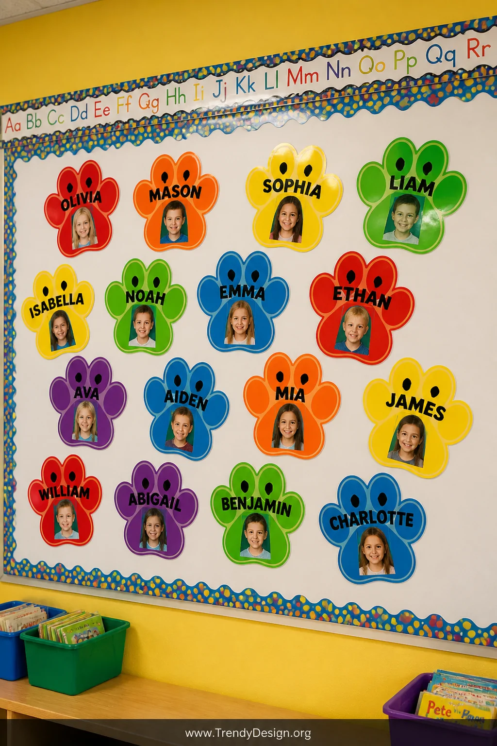 A medium shot of a bright classroom bulletin board covered in bold primary-colored cardstock paw print shapes arranged in a p