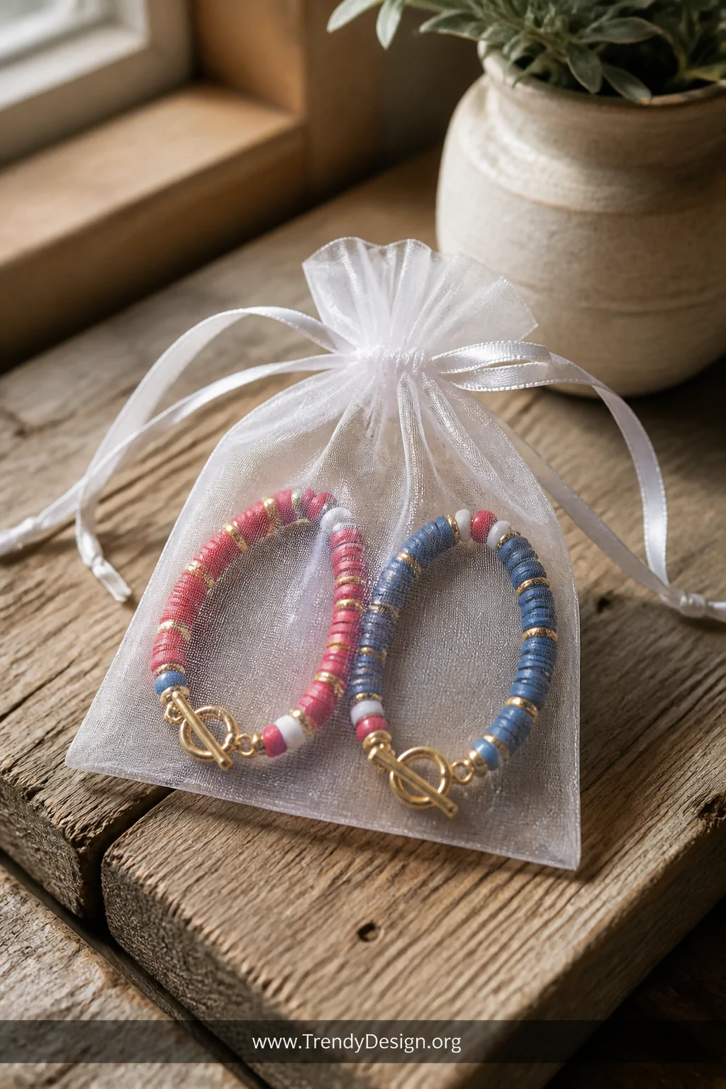 A medium shot of two complementary clay bead bracelets displayed side by side on a rustic reclaimed wood surface, one bracele