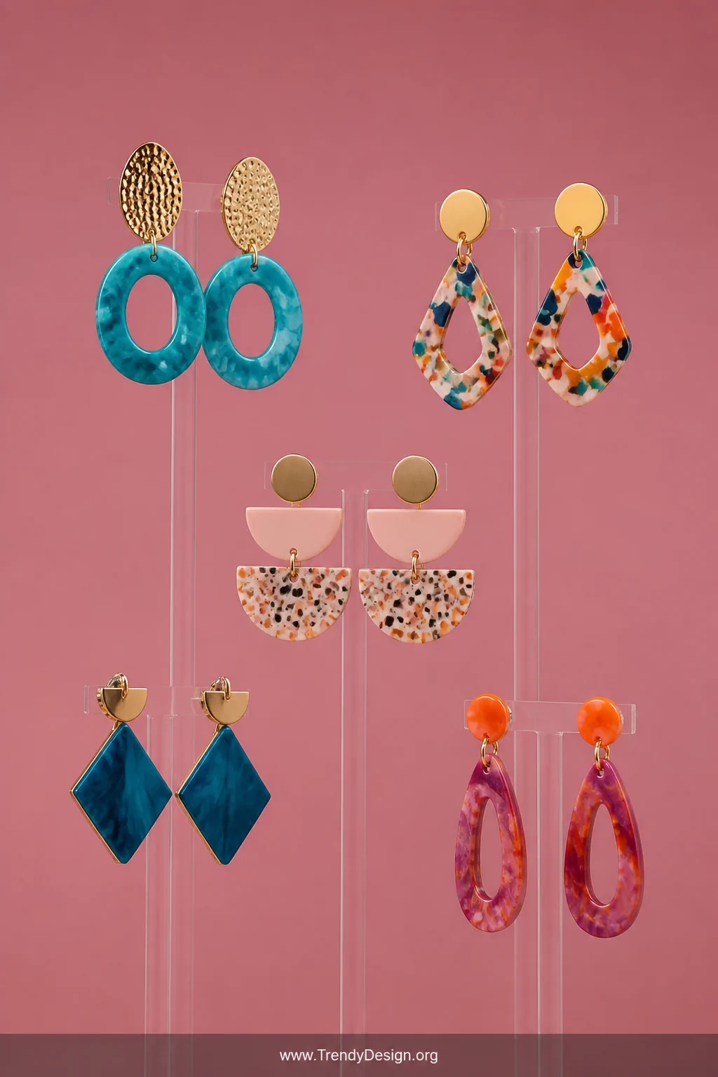 A wide detail shot of bold colorful statement earrings appearing to float in midair on a near-invisible clear acrylic multi-h
