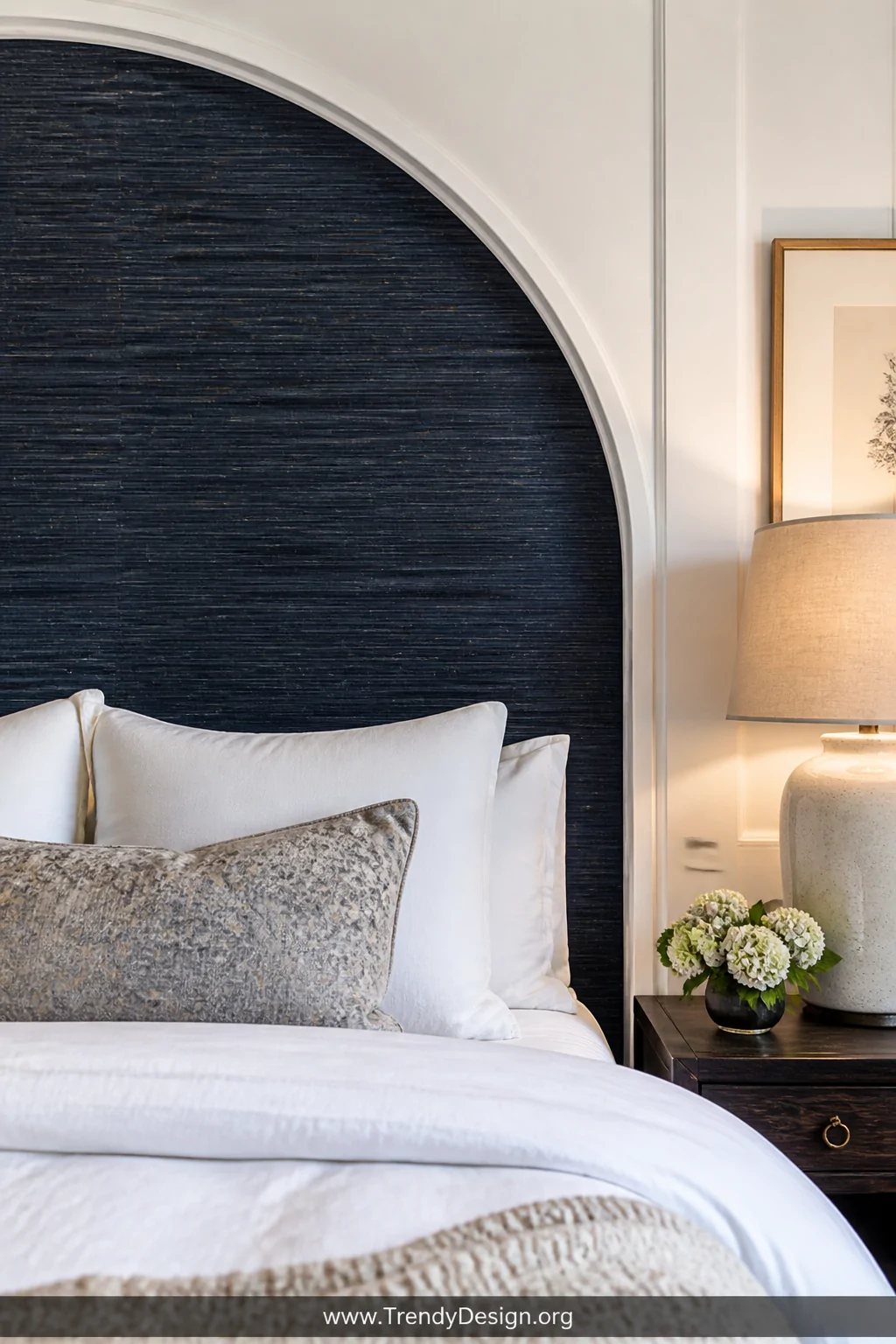 Closeup detail shot of a precisely applied peel-and-stick wallpaper headboard panel in a moody dark inky blue textured grassc