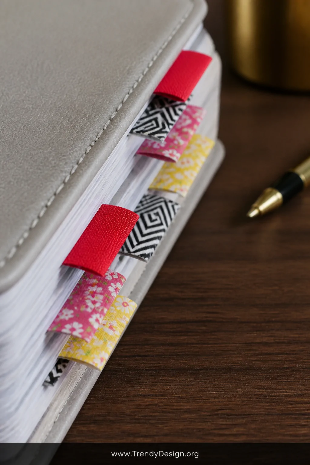 Close-up detail shot of a planner's outer page edges showing a neat color-coded washi tape flag system   folded tabs of brigh