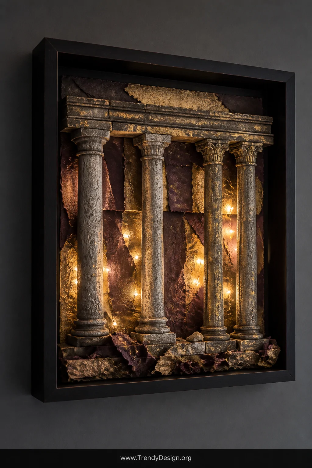 A dramatic detail shot of a deep shadow box frame mounted on a dark charcoal wall, featuring painted wooden dowels with stone