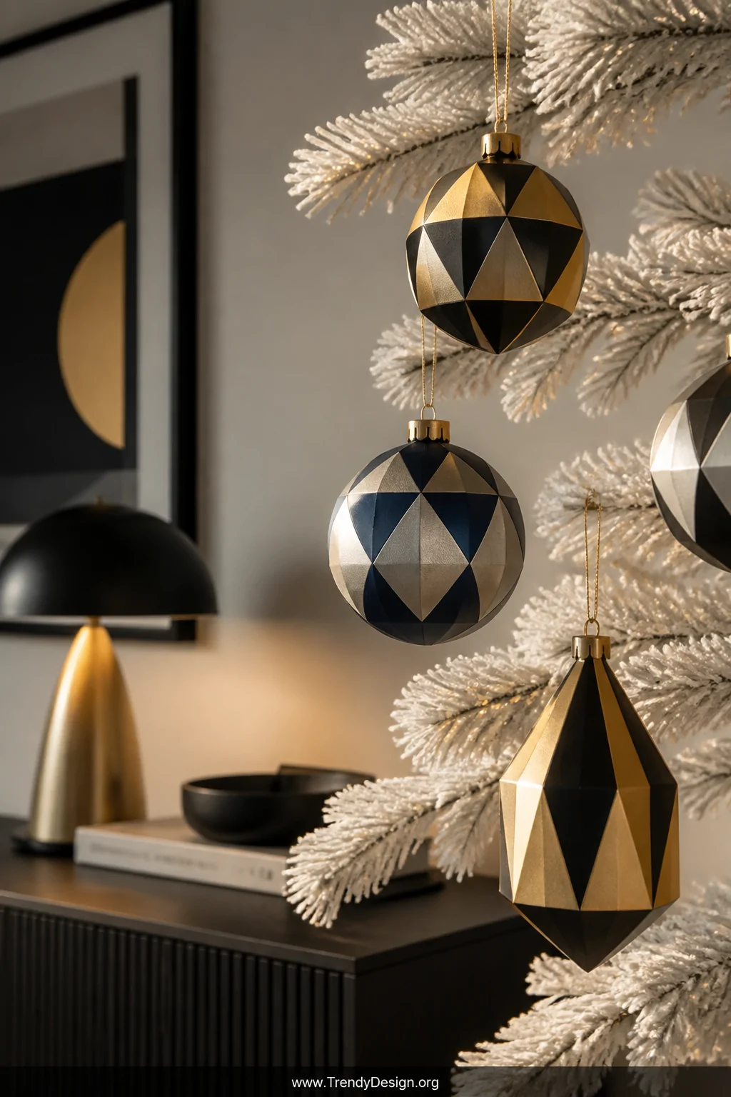 A medium shot of geometric painted Christmas ornaments hanging on a minimalist white-flocked tree branch, featuring crisp mat