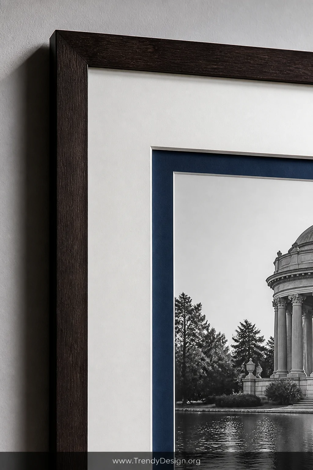 Close-up detail shot of a framed photograph with elegant double matting, a wide white outer mat surrounding a narrow deep nav