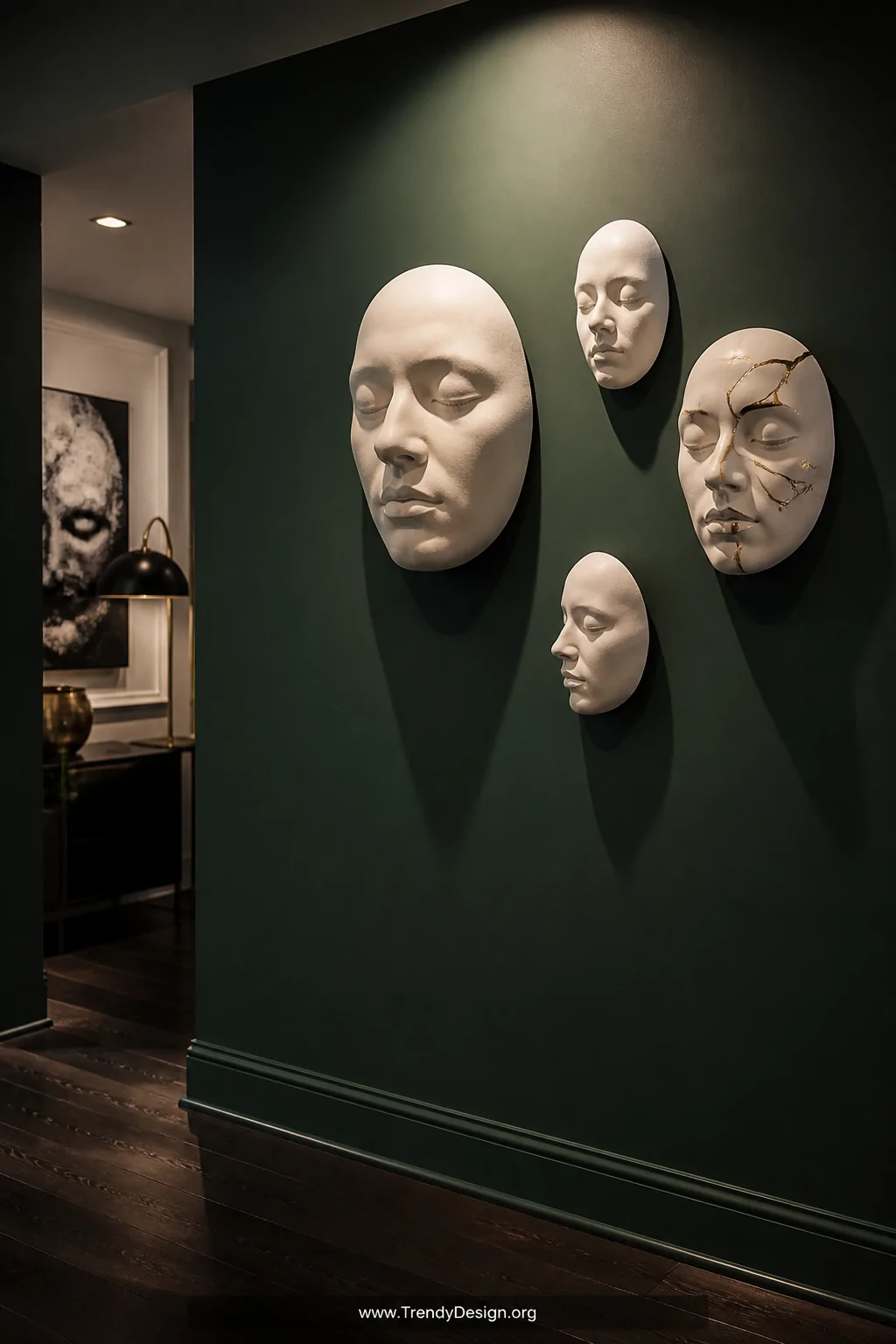 A medium shot of a deep emerald green painted wall displaying a matte white ceramic life-cast face mask mounted at eye level,