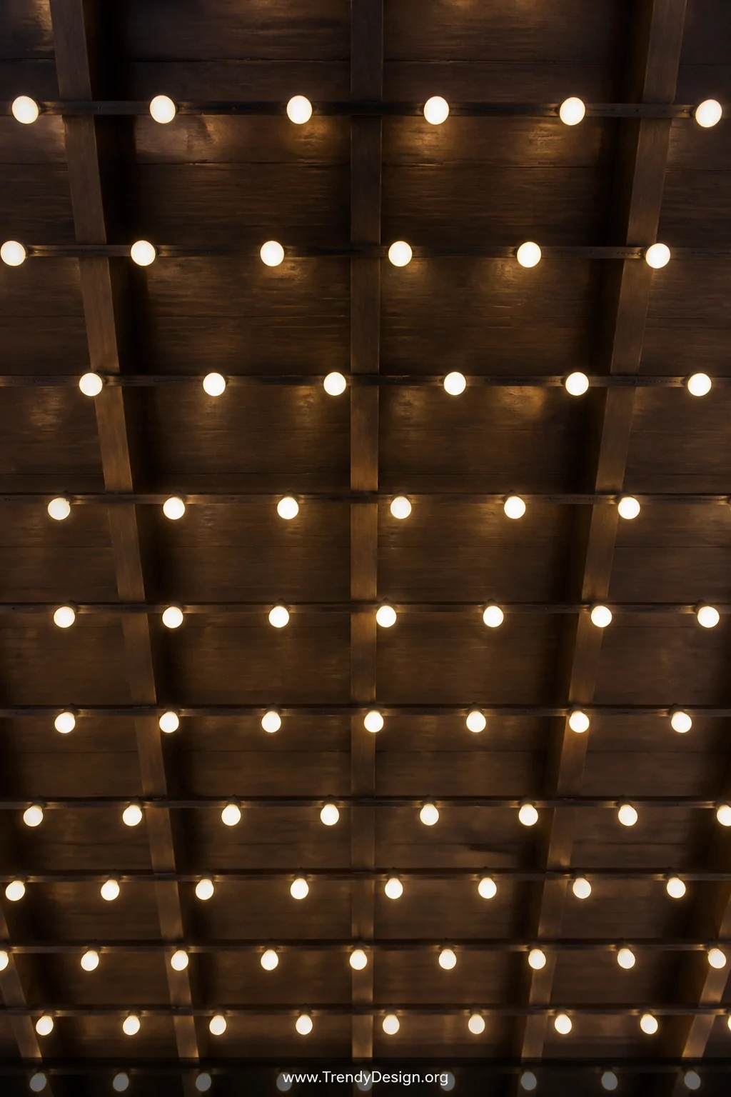 A close-up overhead detail shot looking straight up at a perfectly uniform grid of G50 globe string lights strung in clean pa