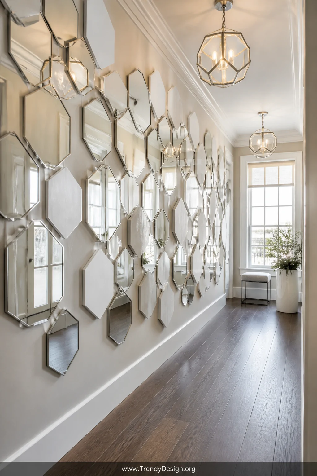 A wide hallway shot covered floor-to-ceiling with an abundant arrangement of fifteen to twenty hexagonal mirrors in mixed siz