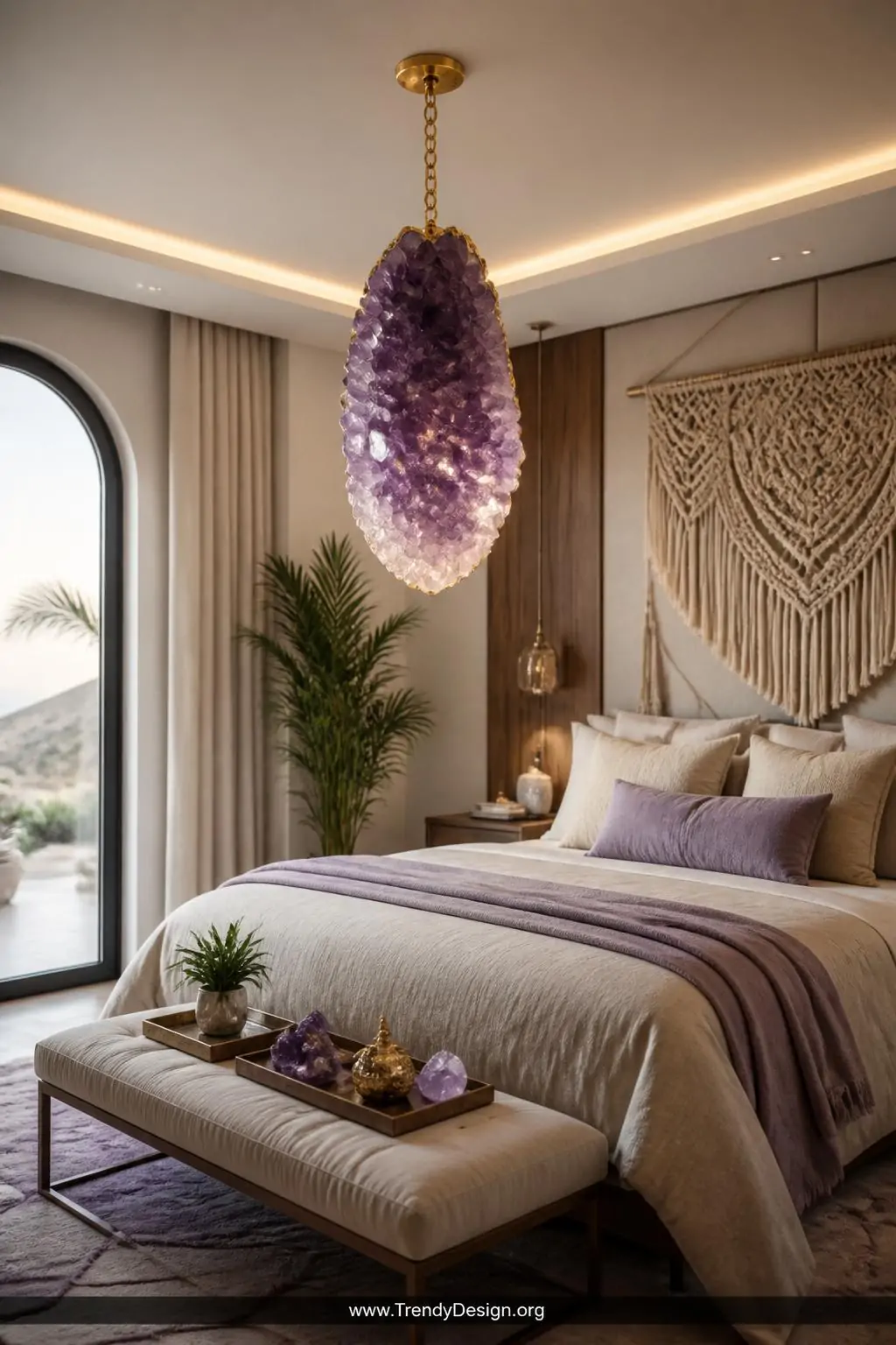 Large raw amethyst pendant cluster hanging from a gold chain ceiling hook above a plush bed with soft cream and lavender bedding, macramé cord accent, warm boutique hotel lighting, wide shot of luxurious boho-modern bedroom.