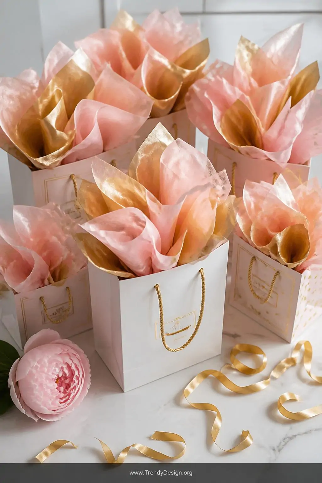 A wide-shot flat lay on a white marble surface showing a collection of paper gift bags overflowing with voluminous layers of 