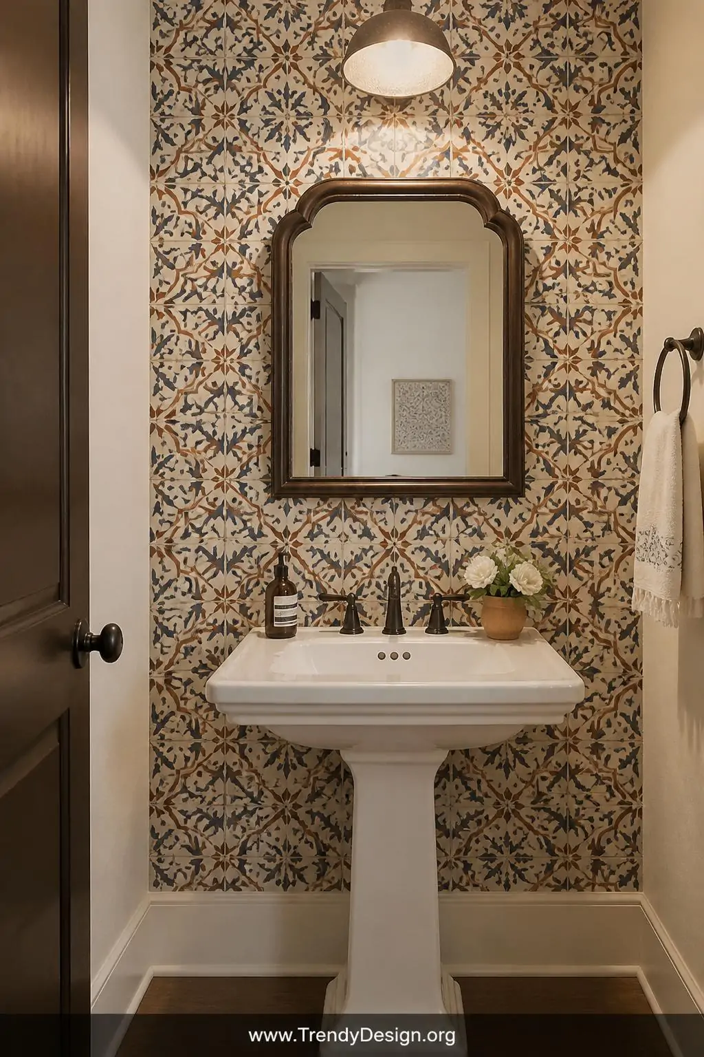 Vintage Moroccan tile-pattern wallpaper in ivory, cobalt, and terracotta geometric repeats installed behind a pedestal sink as a backsplash feature wall in a powder room, soft overhead lighting revealing the intricate pattern detail, medium shot showing the convincing ceramic illusion, photorealistic interior design.