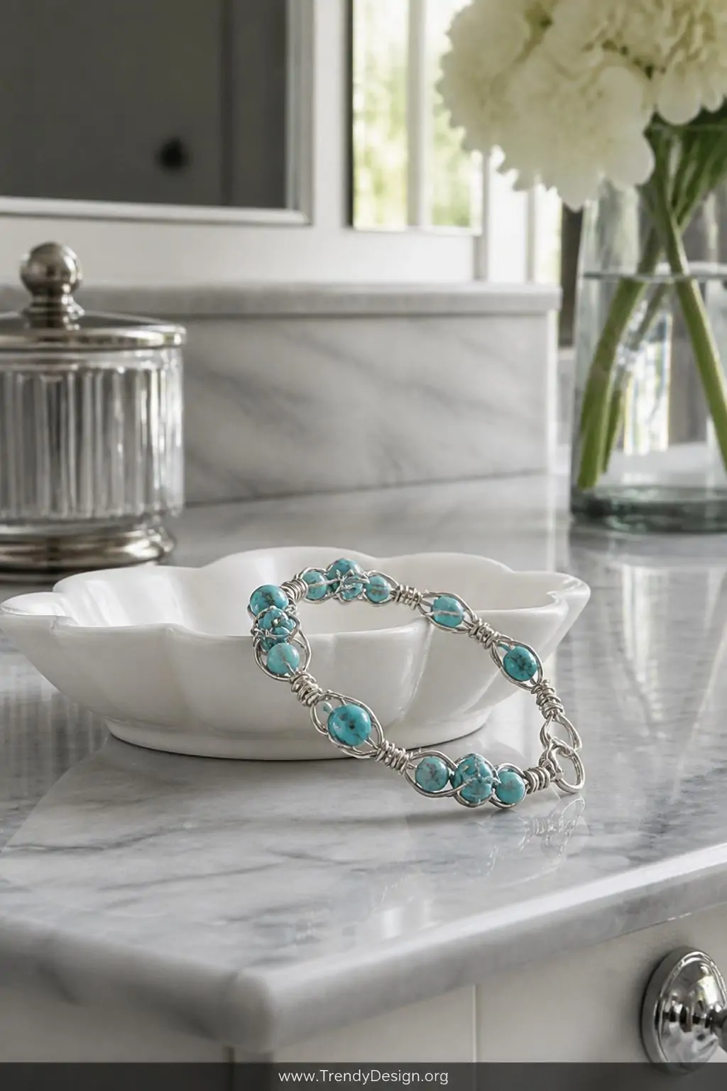 Beaded wire wrap bracelet draped over a white ceramic dish on a marble vanity, soft natural window light, turquoise beads threaded through silver-toned wire creating vivid color pops against cool stone surface, medium shot