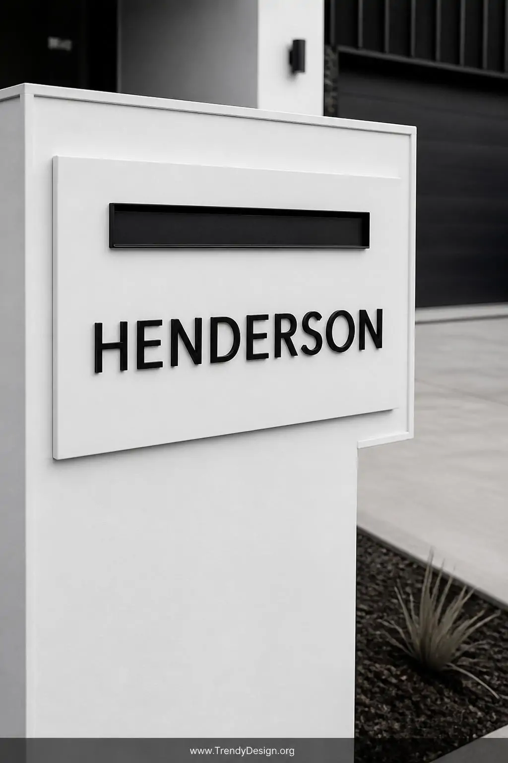 Razor-sharp matte black powder-coated steel letter cutouts spelling a family name mounted flush against a crisp white mailbox
