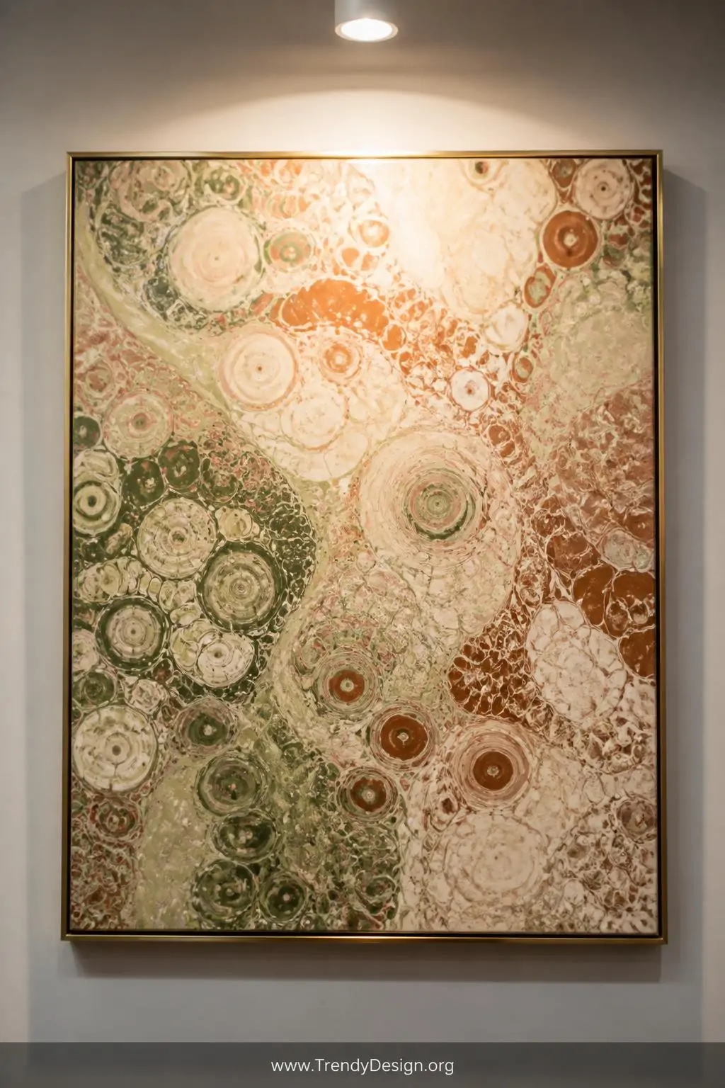 Close-up shot of a framed acrylic pour painting mounted on a white gallery wall, showcasing intricate circular cell lacing pa