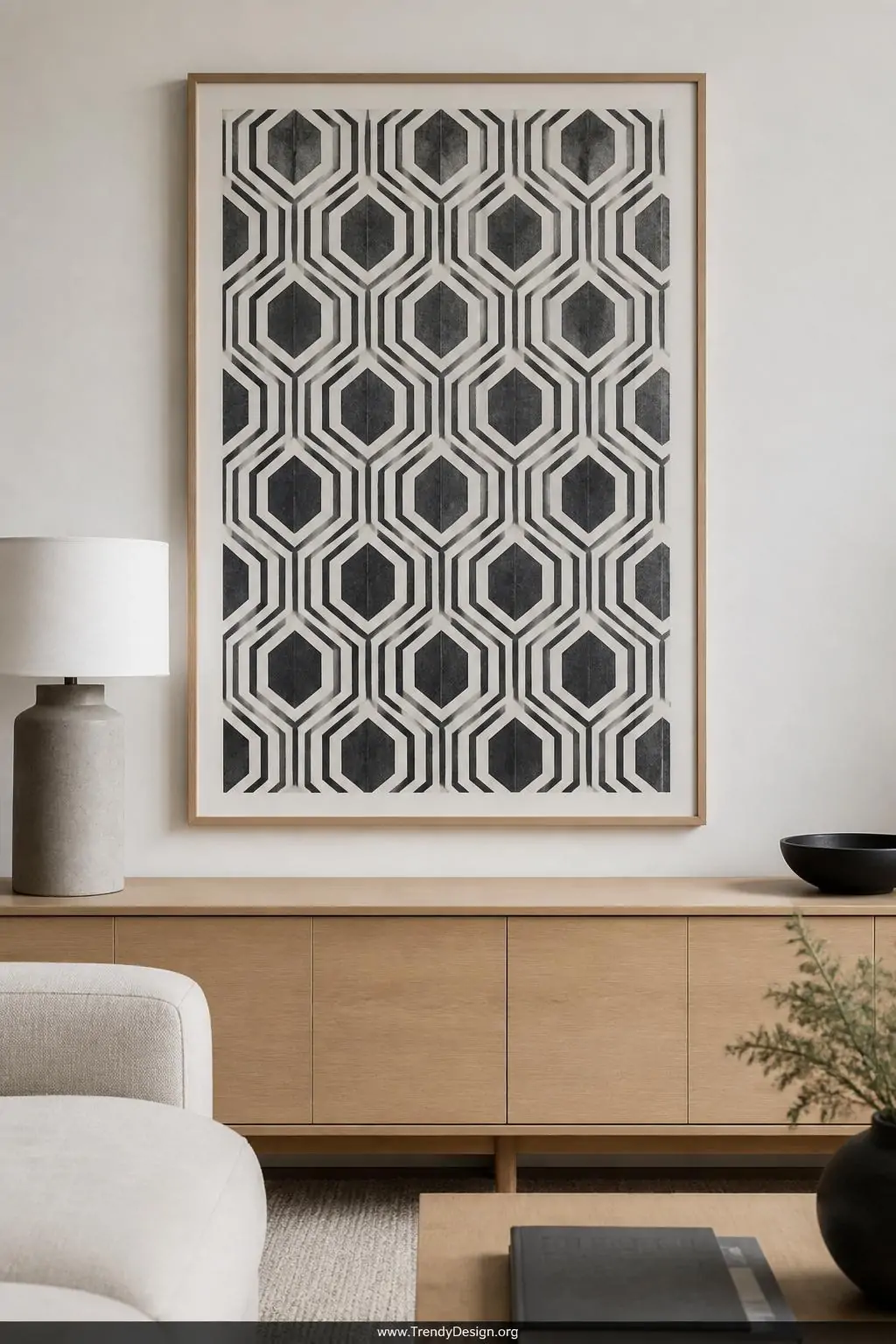 A medium shot of a sleek minimalist living room wall showcasing a large framed geometric linocut grid pattern of repeating he