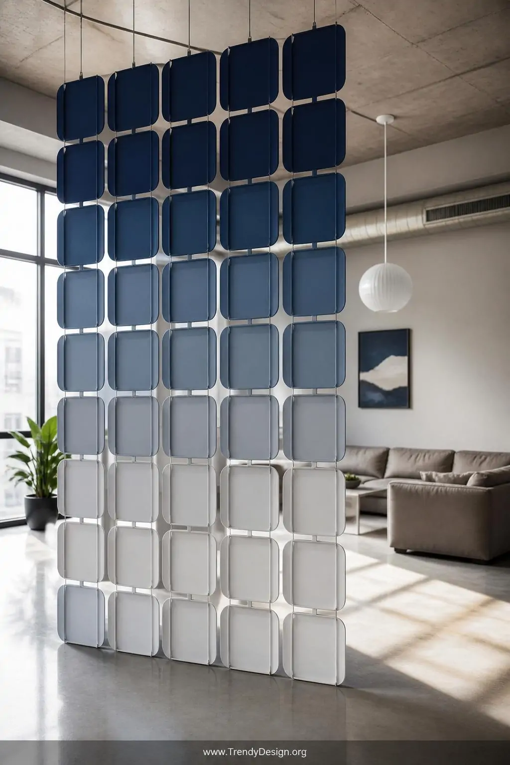 Ombre-painted plastic bread tray room divider in deep navy to soft grey suspended from ceiling hooks with clear fishing line in a minimalist loft living room, geometric grid casting architectural shadows on polished concrete floors, diffused natural light, wide shot.