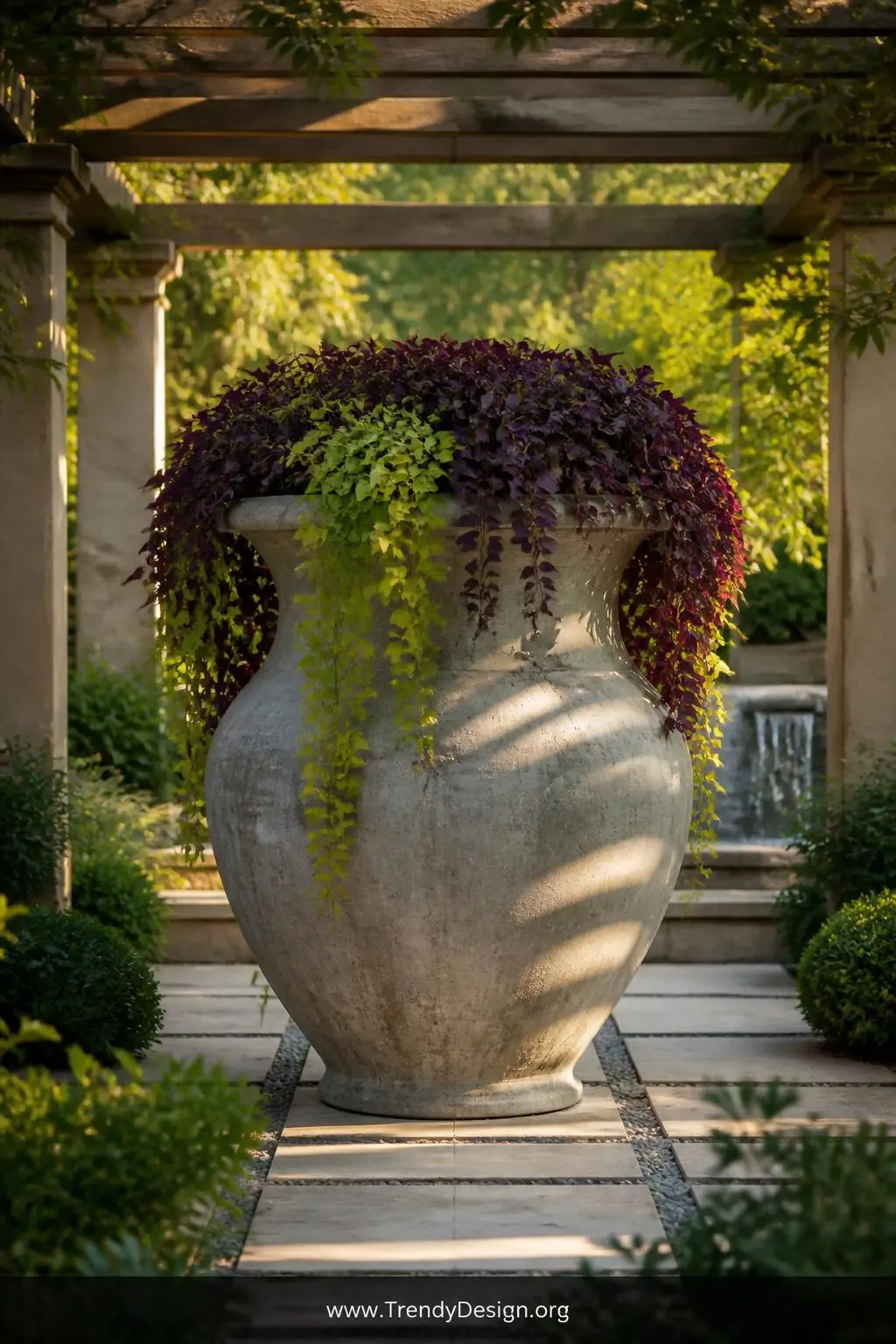 A wide dramatic patio shot centered on a monumental oversized concrete urn as the undisputed focal point, cascading sweet pot