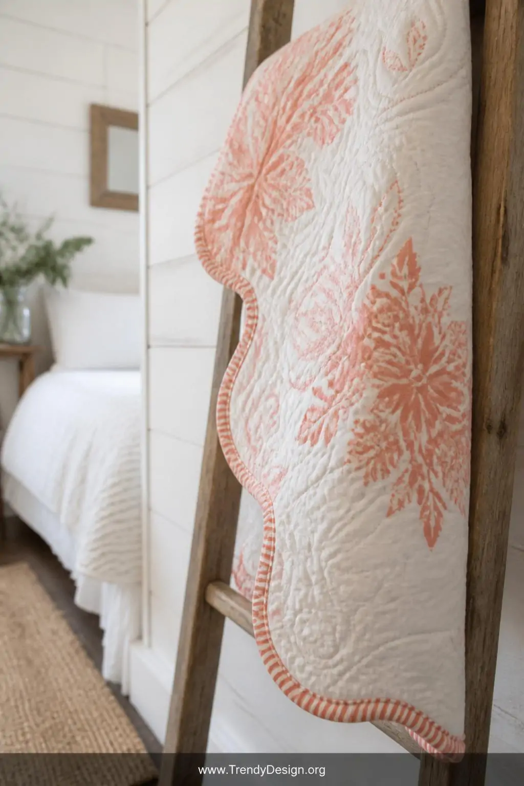 Bias tape binding in a curved coral and white striped fabric hugging the scalloped decorative edge of a quilted throw displayed on a rustic wooden ladder leaning against a whitewashed bedroom wall, soft diffused natural light, closeup shot showing the smooth flexible curve without a single pucker or fold.
