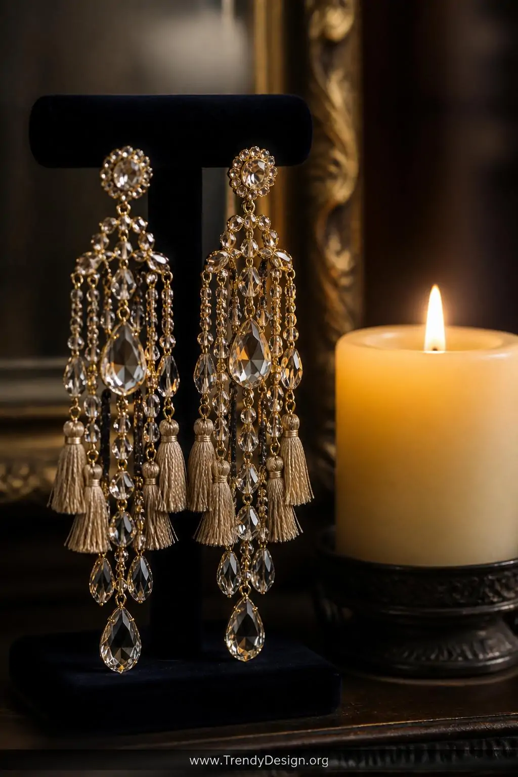 Crystal beaded chandelier earrings dripping with faceted glass drops and thread tassels arranged beside a lit pillar candle on a dark velvet jewelry display stand, candlelight catching every facet, dramatic closeup with shallow depth of field.