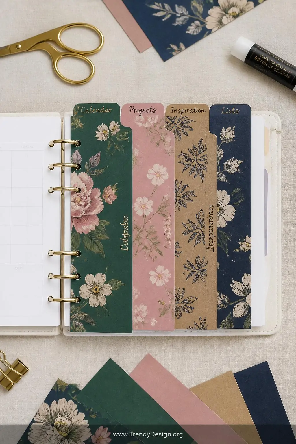 A wide shot of a styled flat lay on a linen-textured cream surface featuring a ring-bound planner open to reveal bold decorat