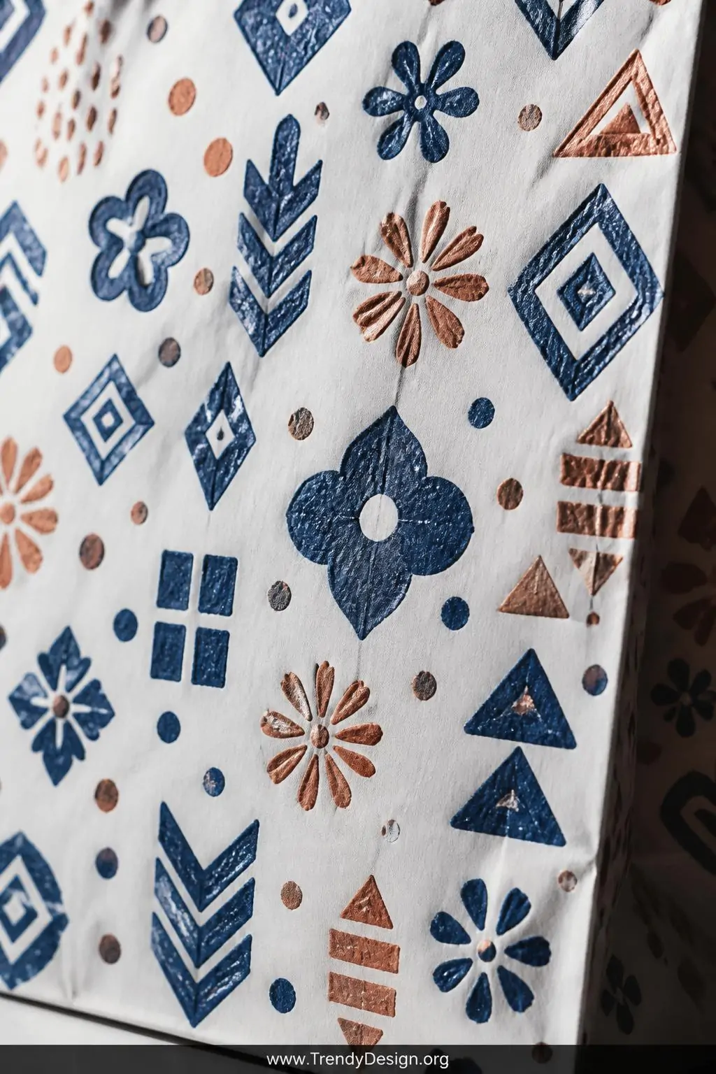 A close-up shot of a plain white paper bag surface densely covered in hand-stamped geometric and floral patterns in deep navy