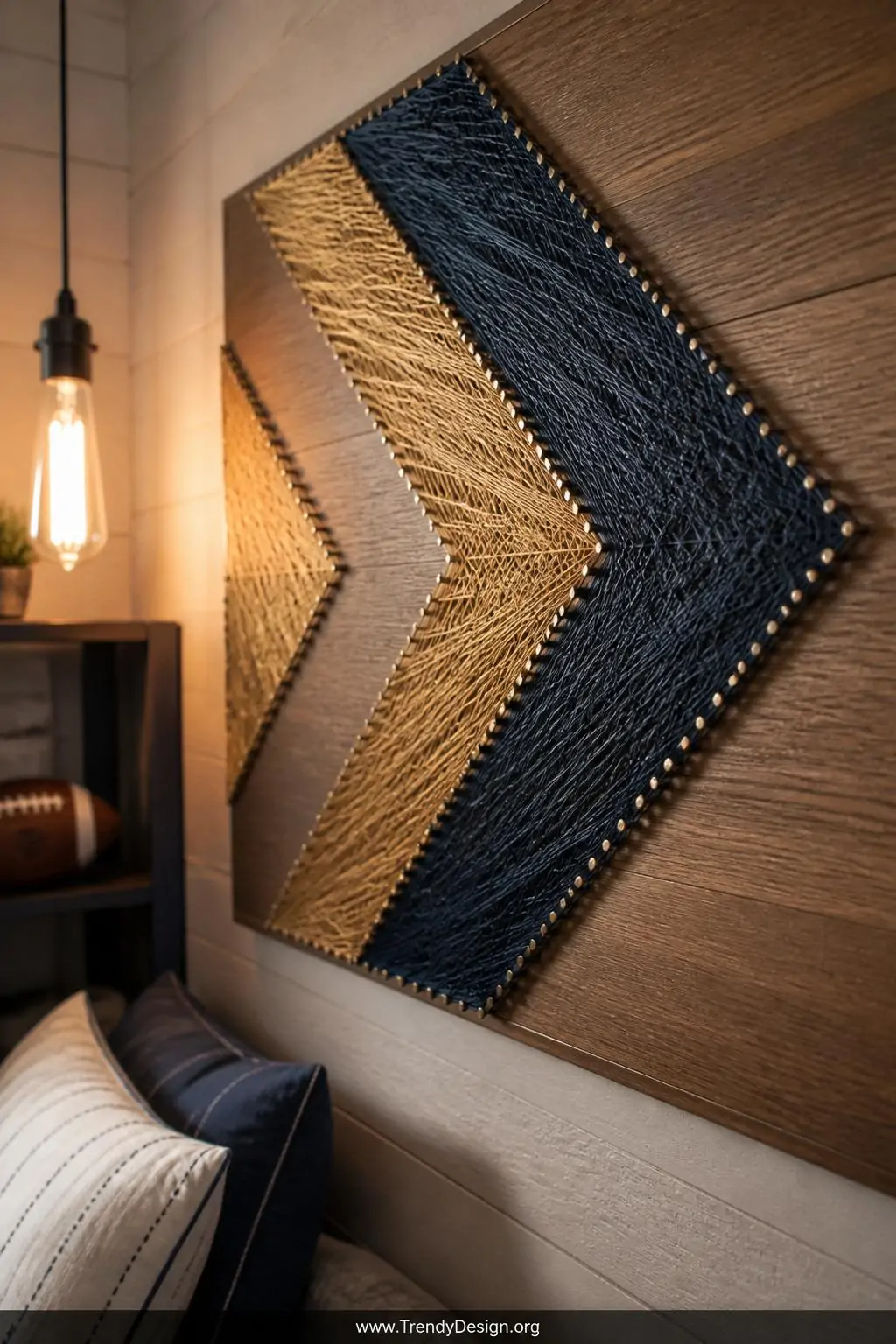 Wooden board string art with metallic gold and matte navy thread woven between small silver nails in a bold arrow pattern, mounted on a whitewashed teen bedroom wall, warm Edison bulb accent lighting highlighting thread texture, closeup