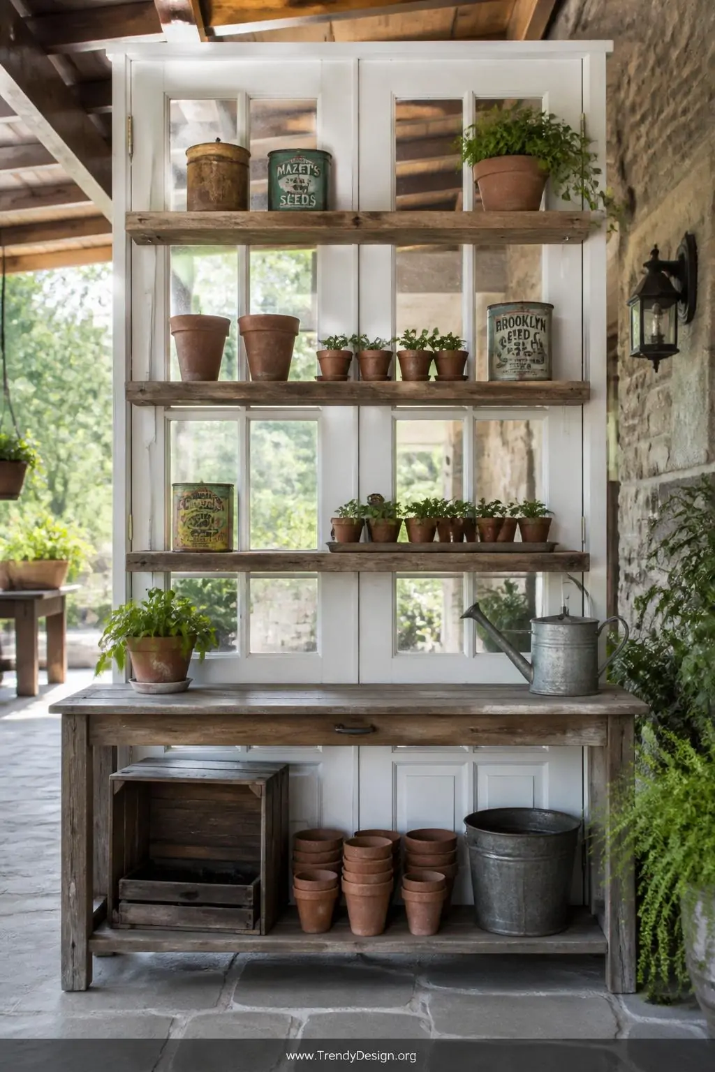 Crisp white French door standing upright as a potting bench backdrop under a covered patio, rough-hewn wooden shelves attached to the frame holding terracotta seedling pots and vintage seed tins, natural daylight streaming through the glass panes, wide shot, photorealistic interior design.