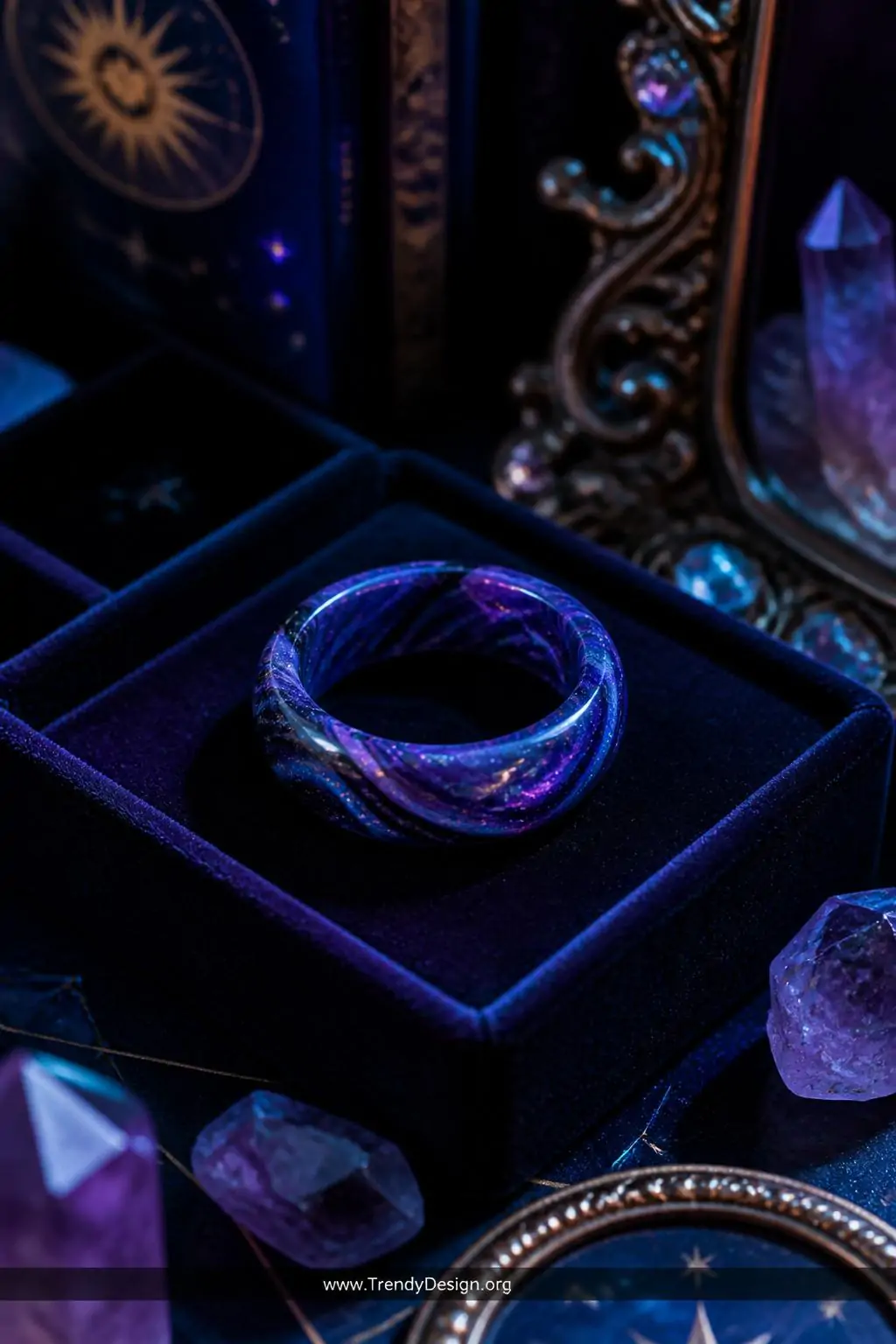 Galaxy-themed polymer clay ring swirling deep purple, midnight blue, and black with holographic shimmer powder resting on a dark velvet jewelry tray, moody studio corner, cosmic maximalist style, closeup shot with cool accent lighting creating an ethereal glow