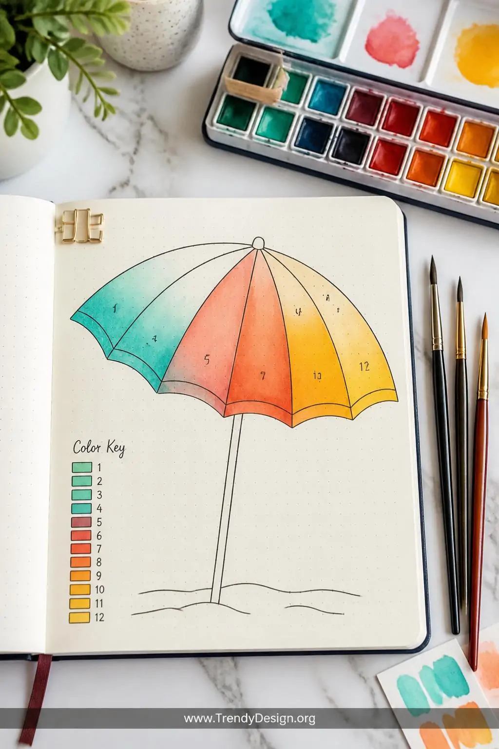 Bullet journal displaying a large bold outline of a beach umbrella divided into numbered sections, partially colored in gradient watercolor washes of turquoise, coral, and golden yellow, surrounded by open watercolor palette and fine brushes resting on a white marble surface, bright studio-style overhead lighting emphasizing vivid pigment saturation, medium shot showing both the illustration and the artistic supplies.