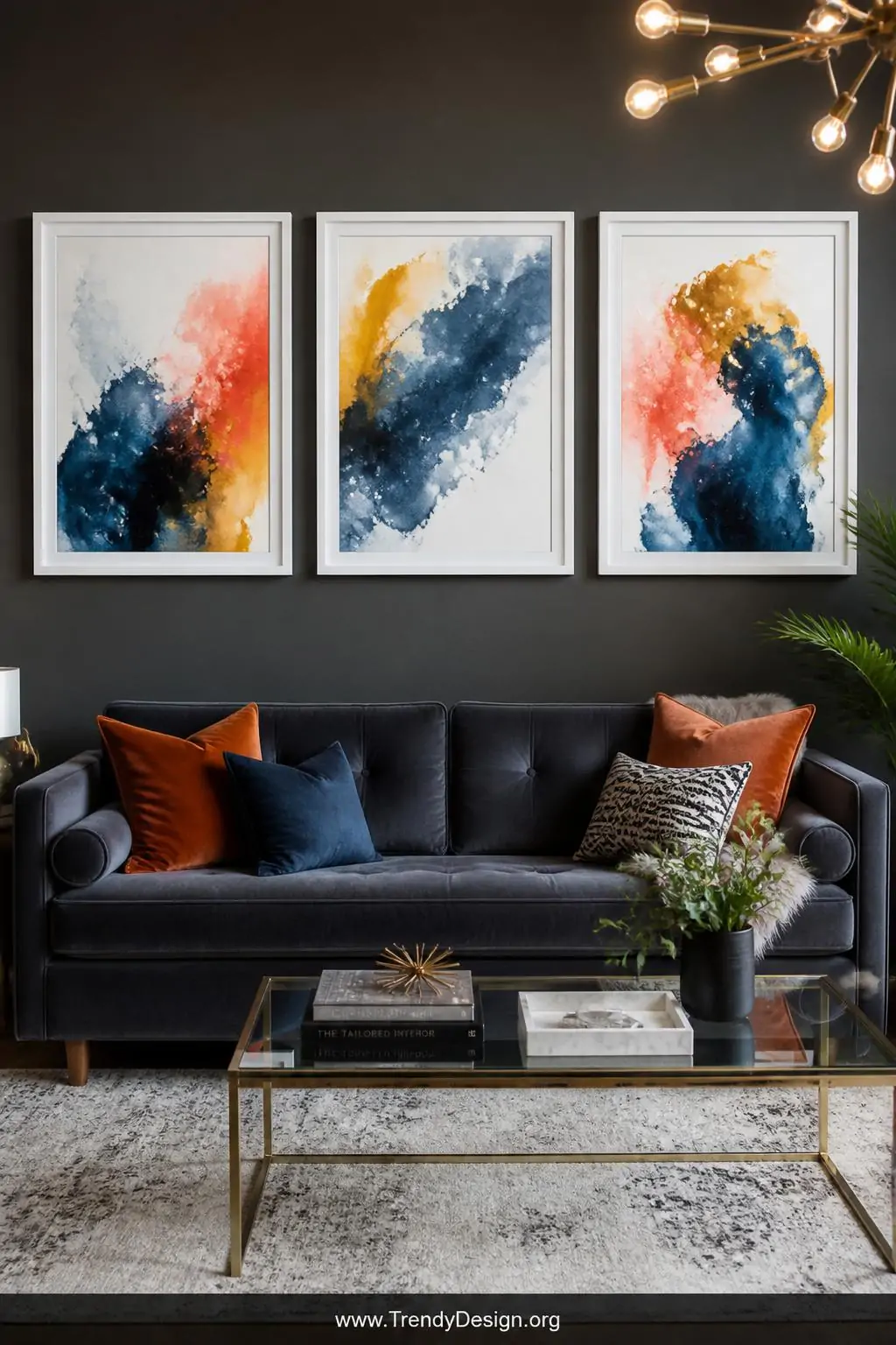 A modern living room gallery wall featuring three framed abstract watercolor splash paintings deep navy pooling into mustard 