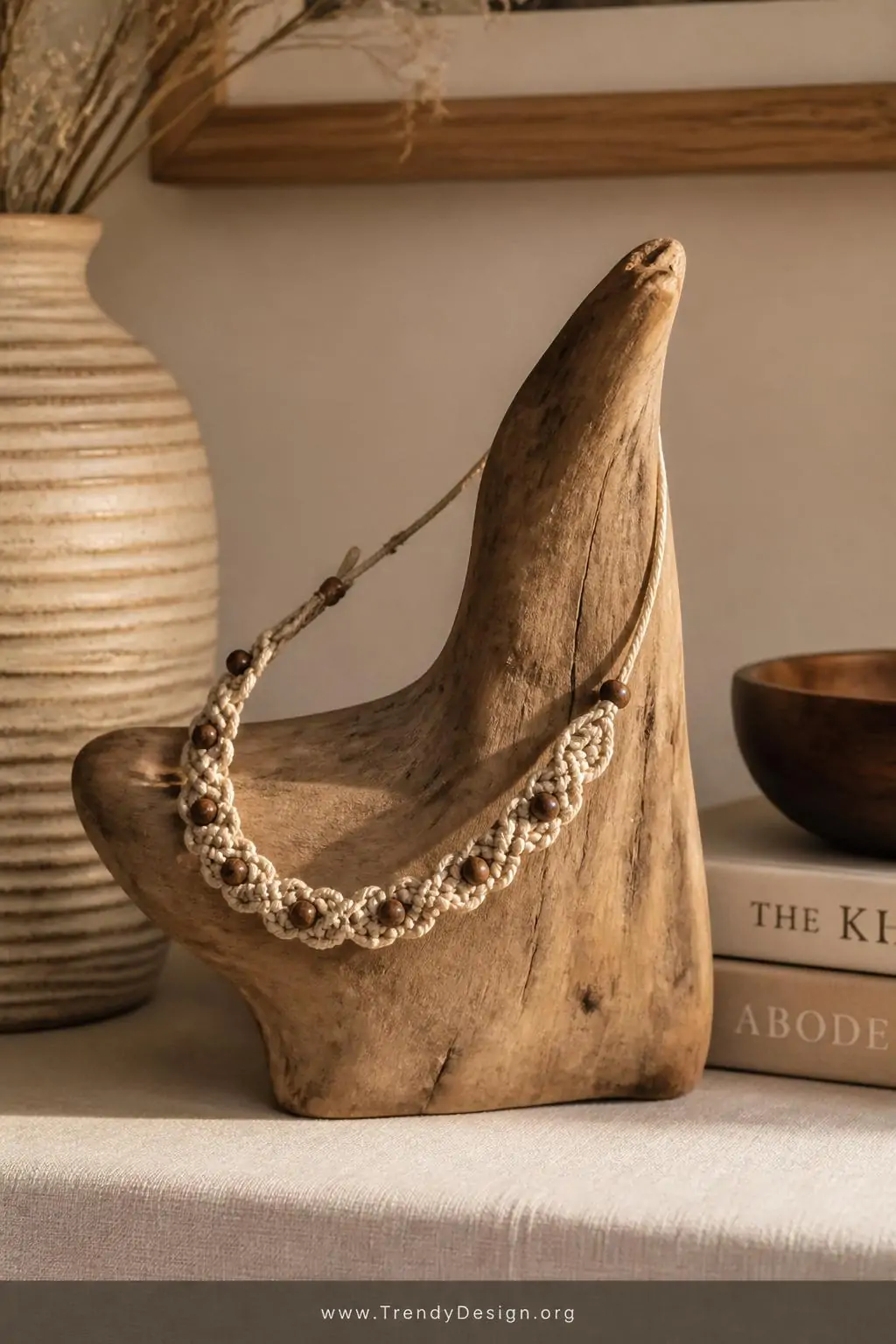 Natural waxed cord macramé knotted choker with small wooden beads draped over a driftwood display stand on a linen-covered shelf, warm afternoon side lighting, medium shot highlighting boho texture and intricate square knot pattern