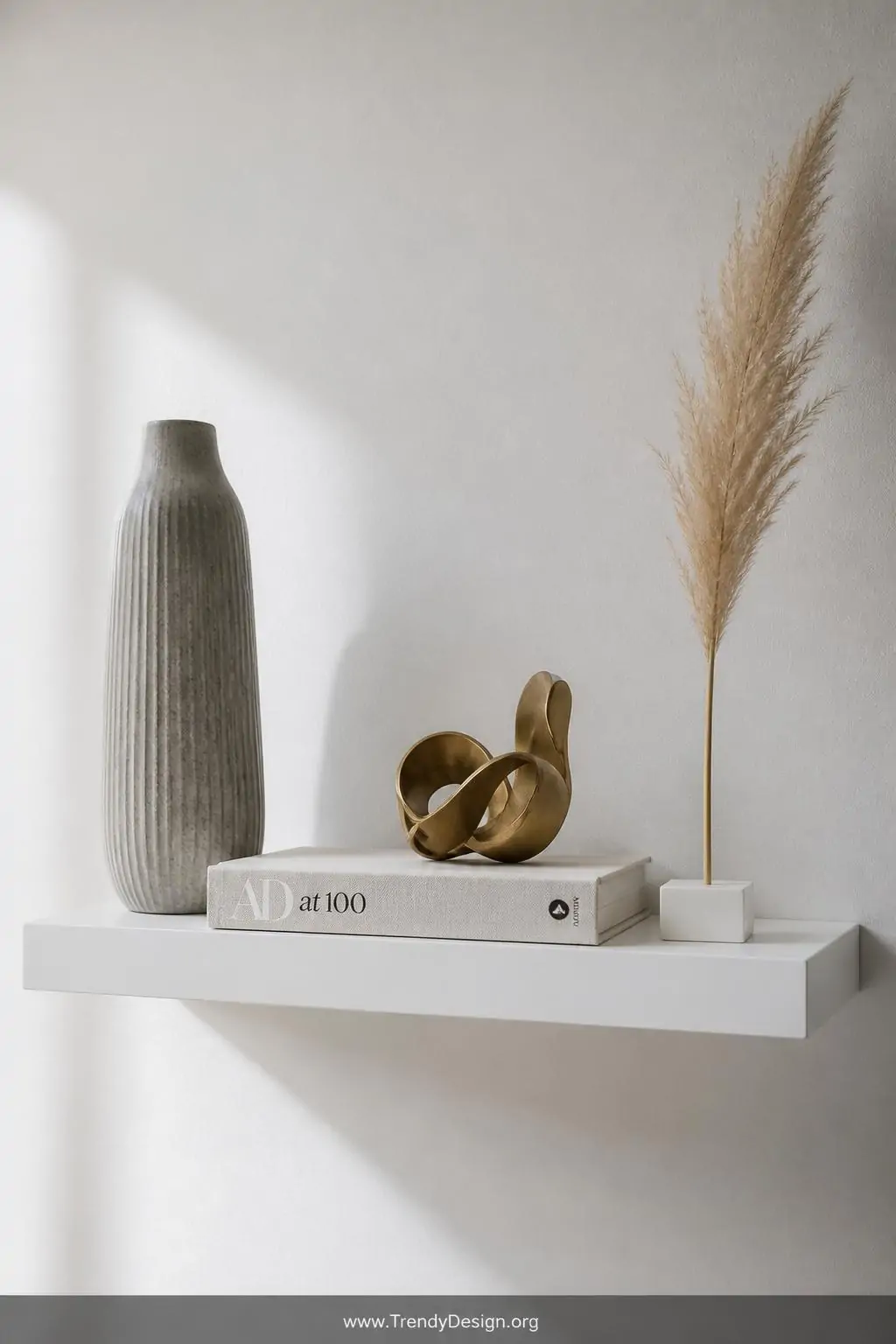 A closeup photorealistic interior shot of a single sleek matte white floating shelf mounted on a crisp white wall, holding ex