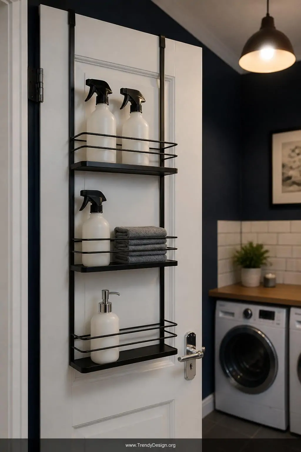 Medium shot of the back of a laundry room door fitted with a sleek matte black metal over-door organizer featuring three tier