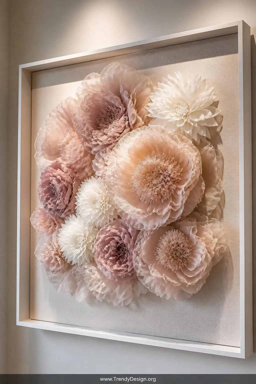 Medium shot of an oversized fabric floral wall sculpture mounted on a stretched canvas inside a deep white shadow box frame, 