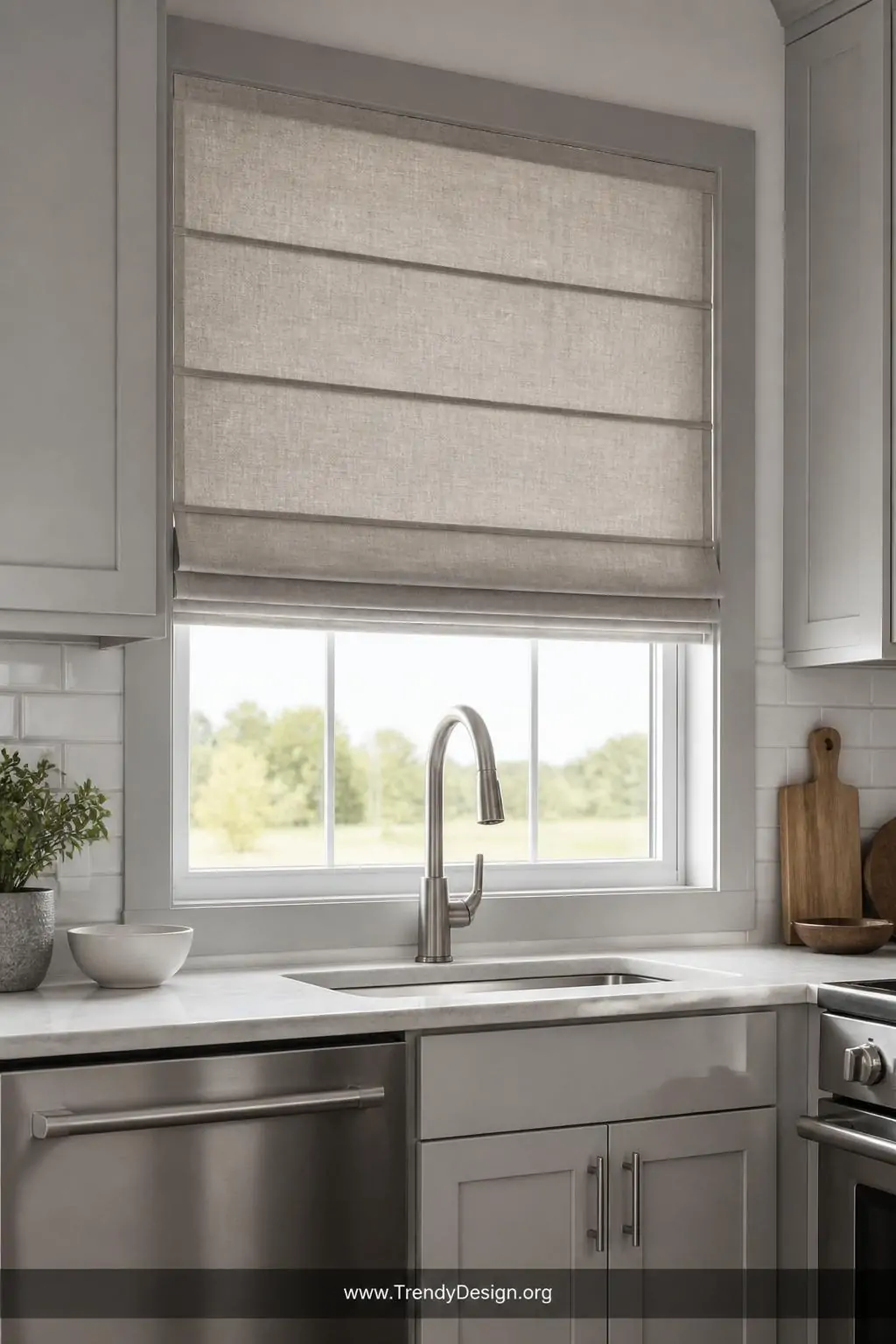 Crisp stone-colored linen Roman shade pulled halfway down over a modern kitchen window above stainless steel appliances and pale gray cabinetry, closeup shot highlighting the clean folded pleats and matte texture in cool diffused daylight, photorealistic interior design.
