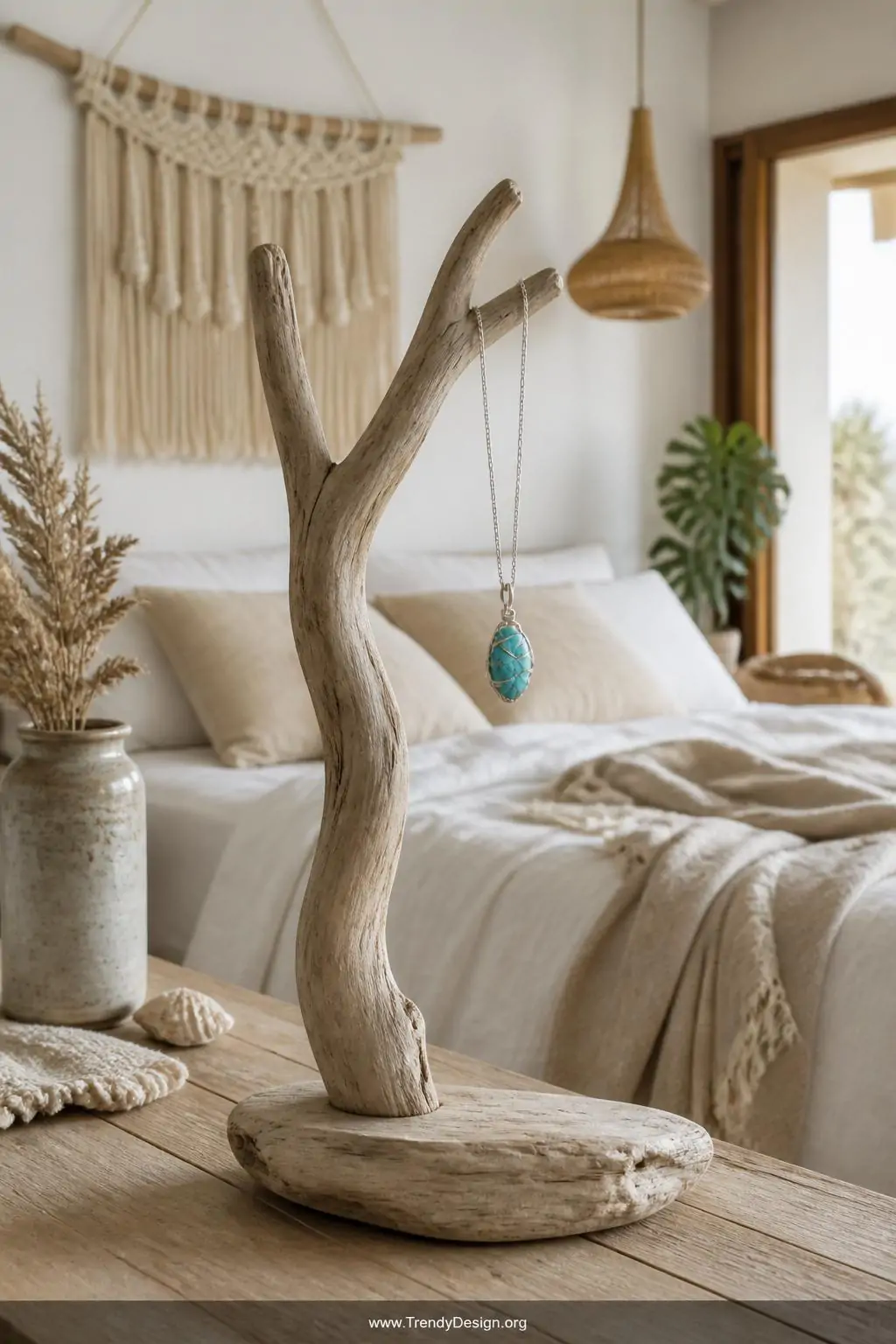 Single turquoise nugget pendant wrapped in sterling silver wire hanging from a rustic driftwood display stand in a bright bohemian bedroom, clean natural daylight, wide shot showing the pendant among simple linen textures and neutral decor