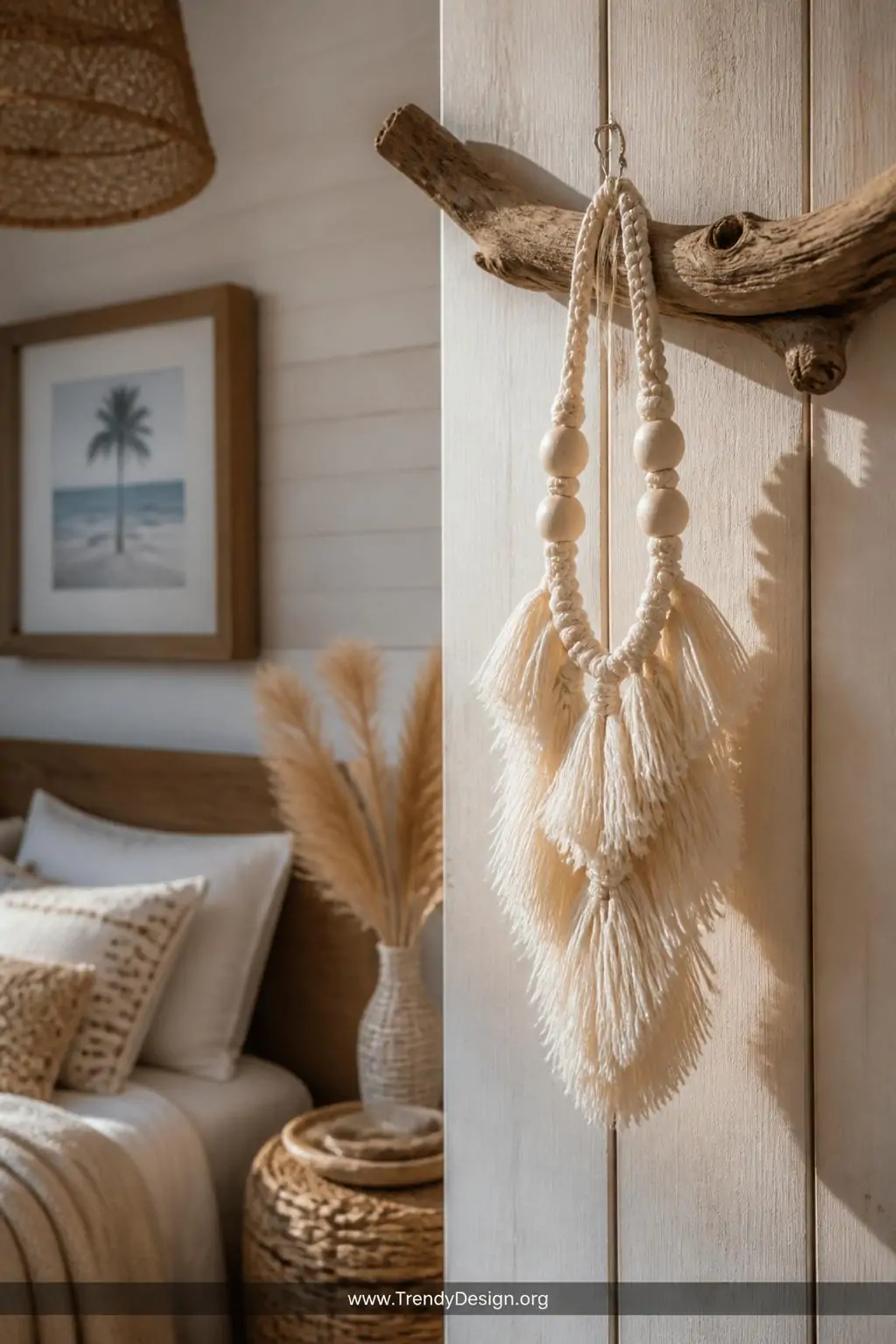 Fluffy cream boho tassel macrame bracelet displayed hanging from a small driftwood branch mounted on a whitewashed plank wall, warm raking side light emphasizing the brushed-out cord texture and layered fringe movement, medium shot in a relaxed coastal bohemian bedroom corner.