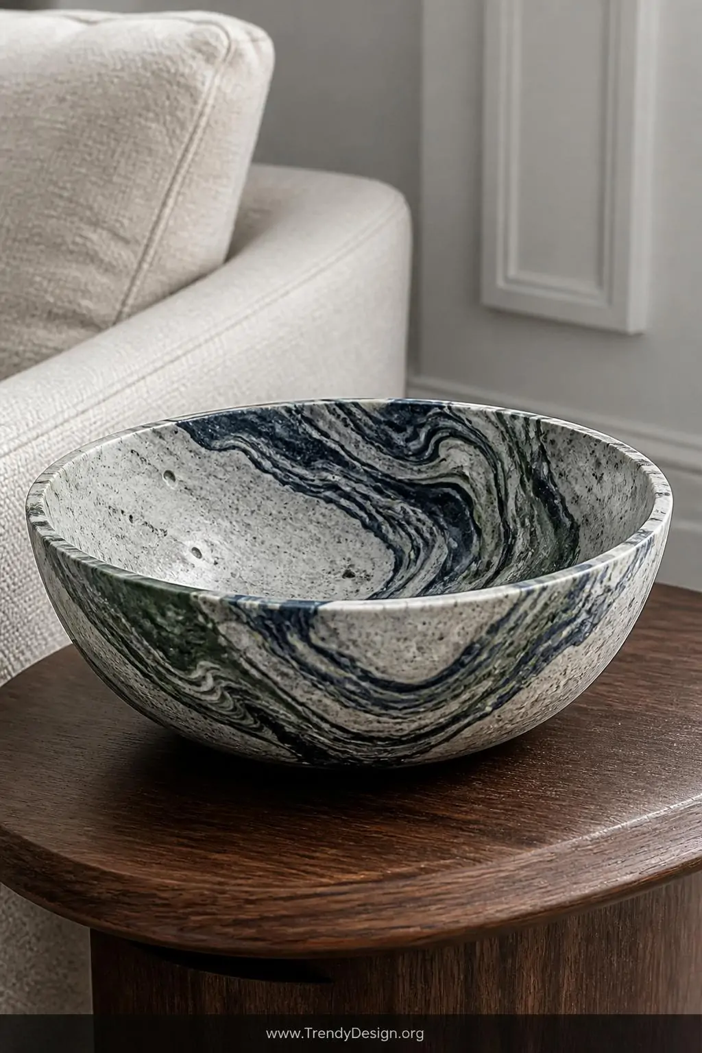 A stunning marbled concrete bowl featuring dramatic swirling veins of deep navy blue and forest green cutting through pale na
