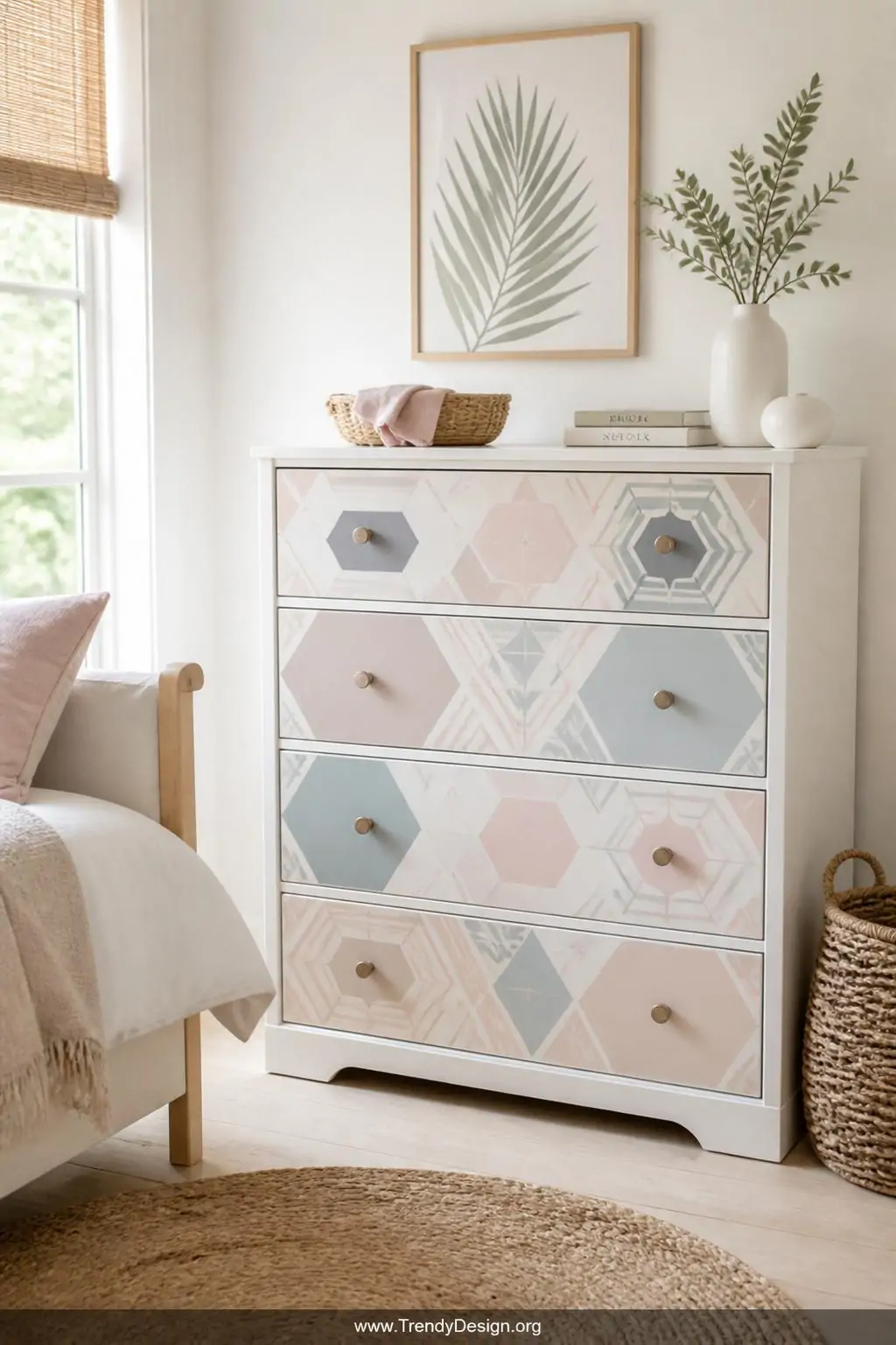 Bold hexagon and diamond geometric sticker sheets in dusty pastel tones applied to the drawer fronts of a plain white dresser, bright airy afternoon light, medium shot of a minimalist bedroom corner with pale wood flooring and woven texture accents.