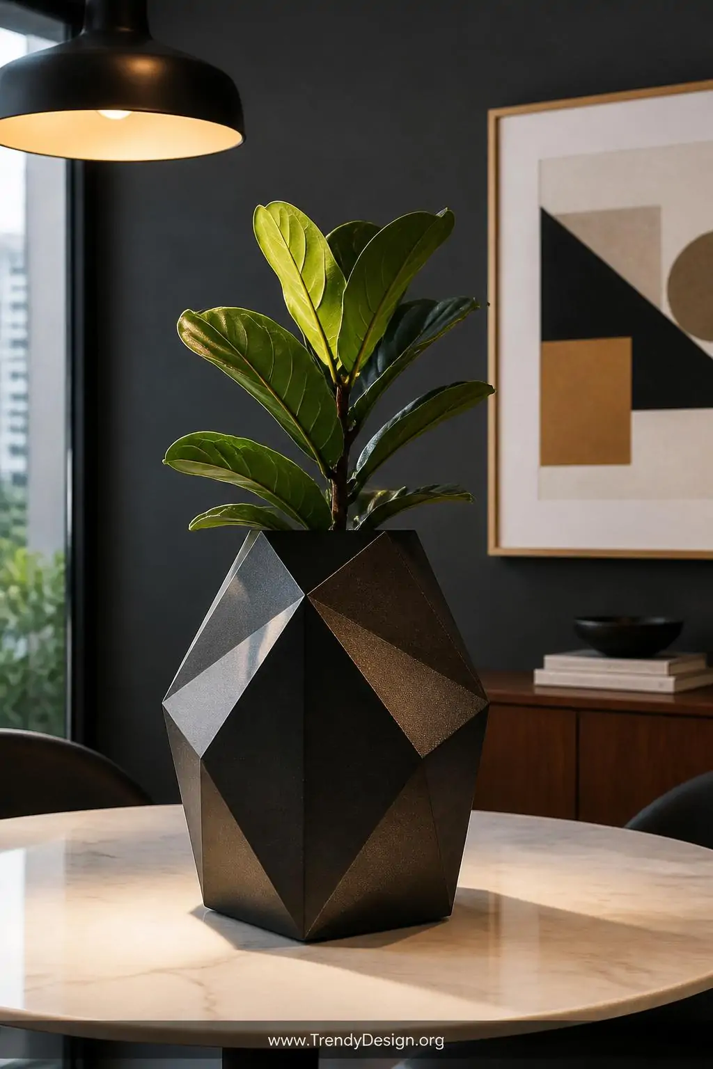 Geometric diamond-shaped cardboard planter with matte black metallic spray paint finish holding a small potted fiddle leaf fig on a marble dining table, warm pendant light casting sharp angular shadows across the multifaceted sculptural surface, medium shot styled against a dark charcoal accent wall, photorealistic interior design