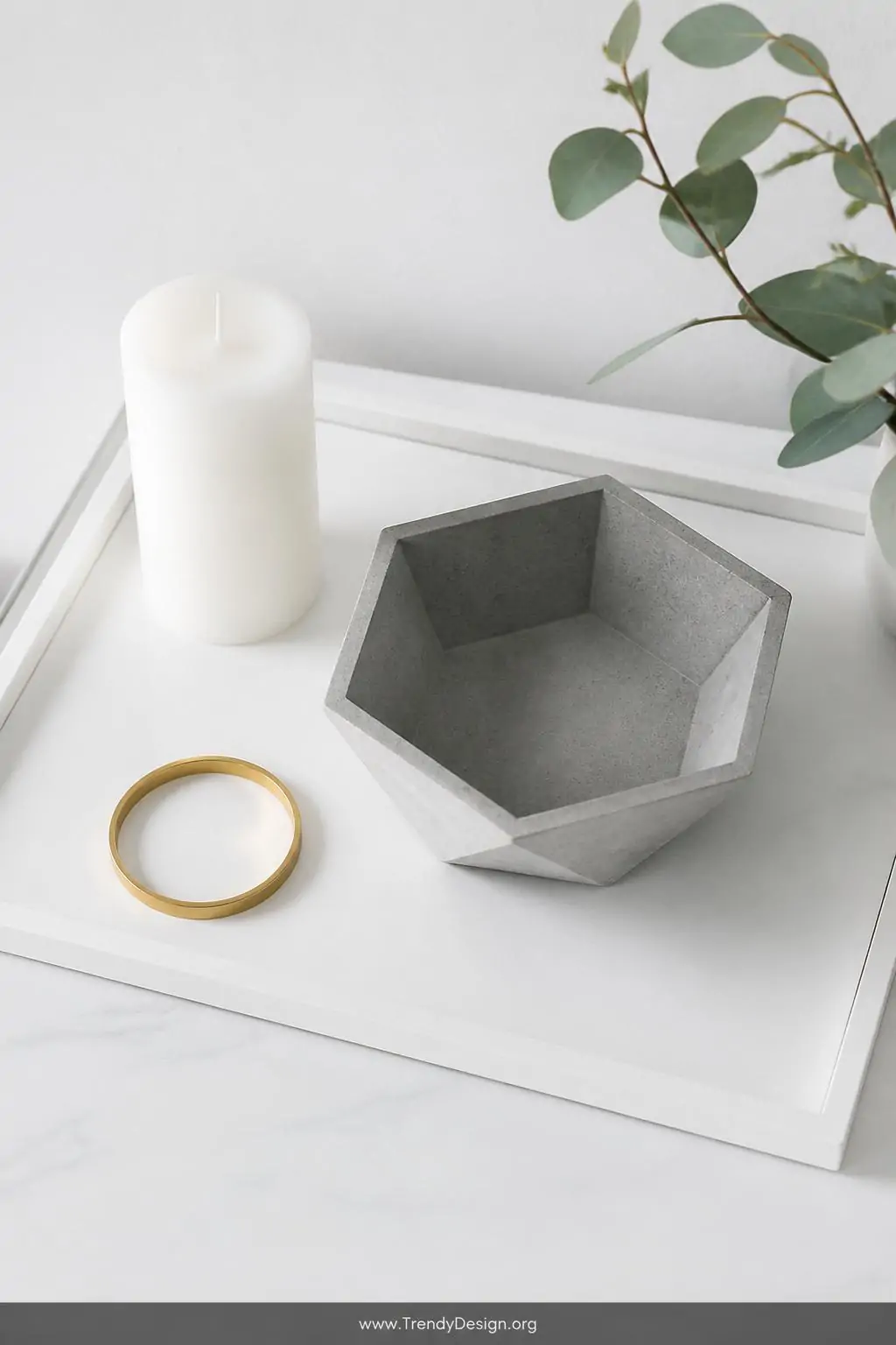 A sharp hexagonal concrete bowl with perfectly angular geometric facets and clean architectural edges sits on a white Scandin