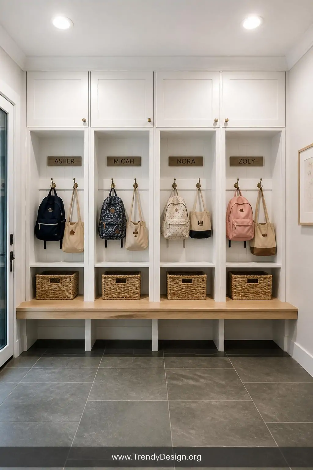 A wide-angle photorealistic interior design shot of a built-in row of four individual white shaker-style cubbies spanning an 