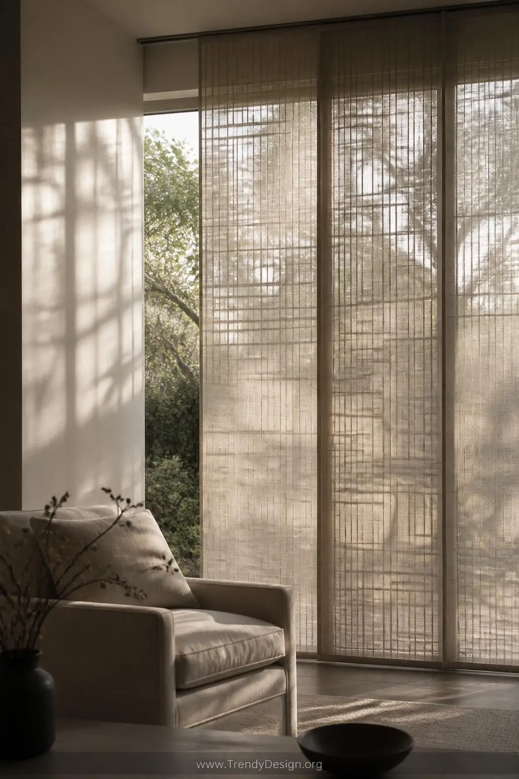 Medium shot of a modern living room window dressed in geometric woven sheer panels with a subtle grid pattern in soft warm gr
