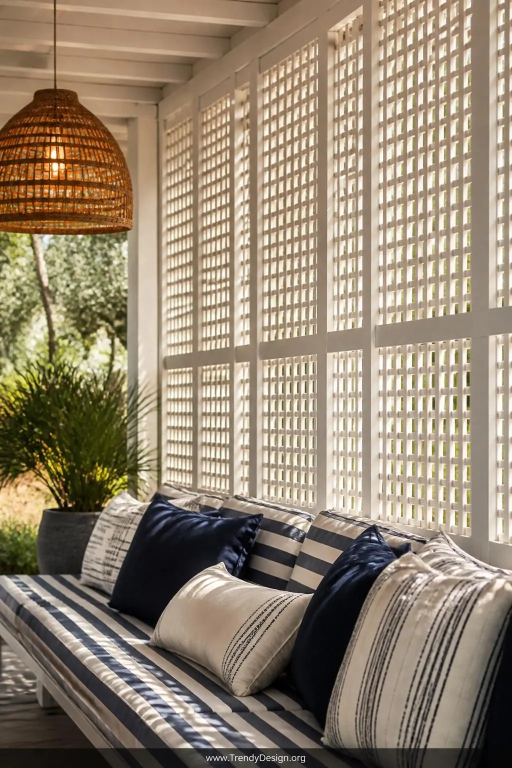 Wide photorealistic shot of tall white lattice privacy screen panels enclosing the side of a cozy porch, a plush outdoor sofa