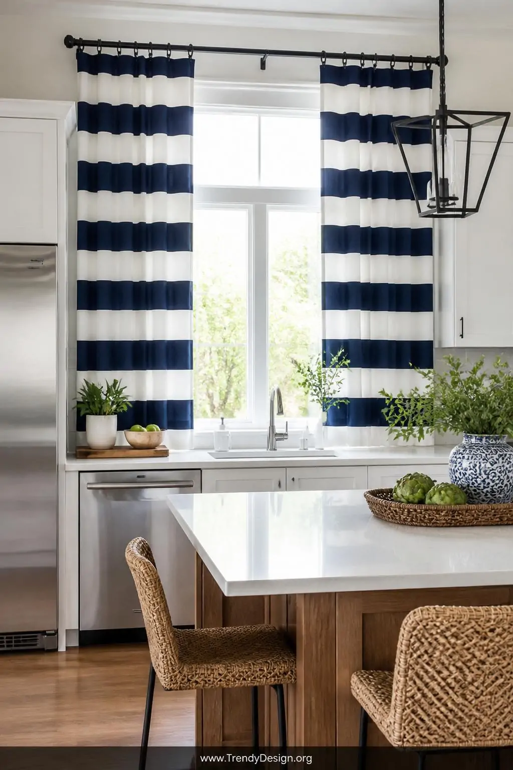 Navy and white horizontal striped cotton curtain panels hung high and wide on a sleek rod in a bright kitchen with white shaker cabinetry, stainless appliances, and warm wood accents, wide shot, crisp natural daylight giving the space a fresh coastal energy, photorealistic interior design.