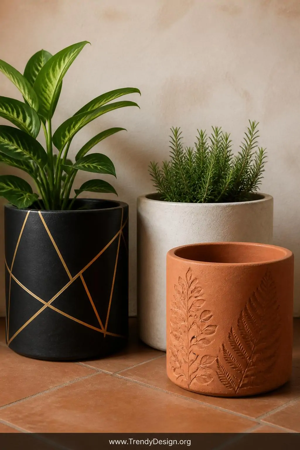 A medium shot of a collection of painted concrete planters arranged on warm terracotta floor tiles, featuring one in matte bl