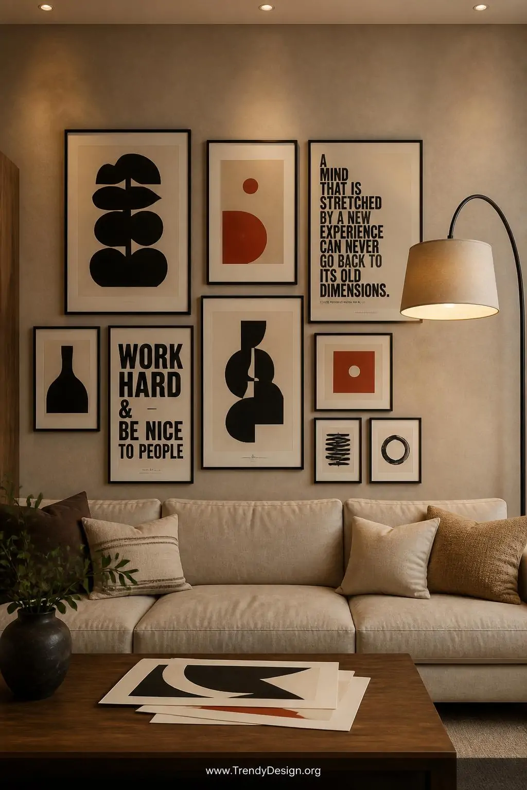 Wide shot of a cozy living room gallery wall featuring multiple framed screen printed artworks in simple black frames against